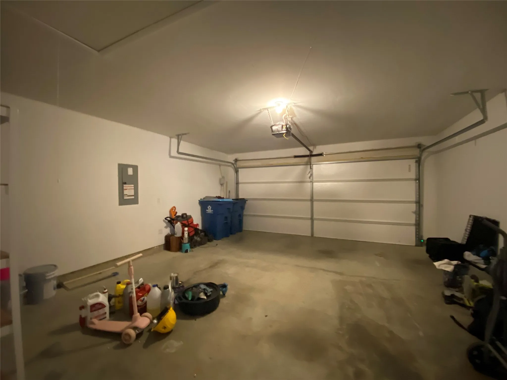 Garage featuring a garage door opener and electric panel