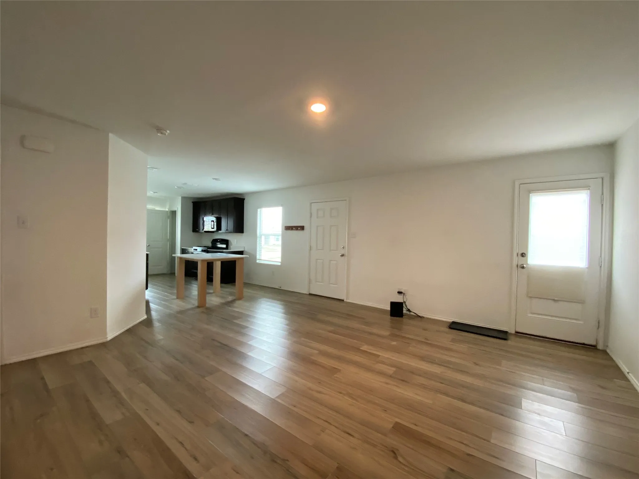 Unfurnished living room with baseboards and wood finished floors