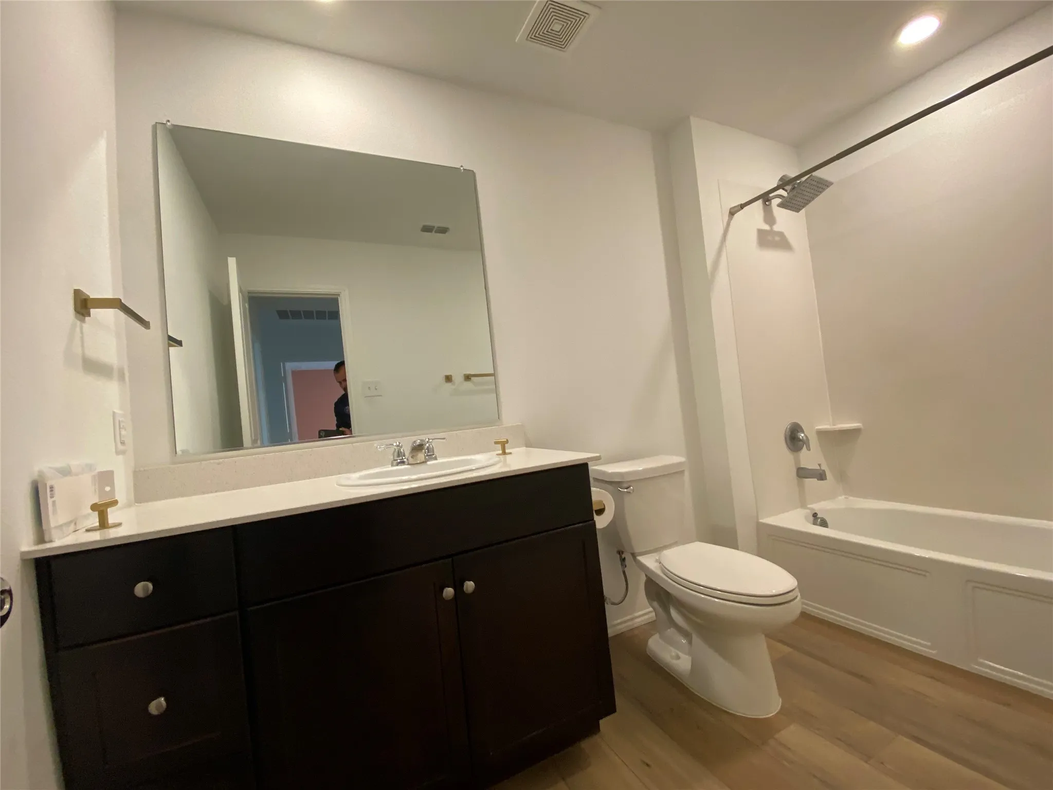 Full bathroom featuring toilet, vanity, wood finished floors, and visible vents