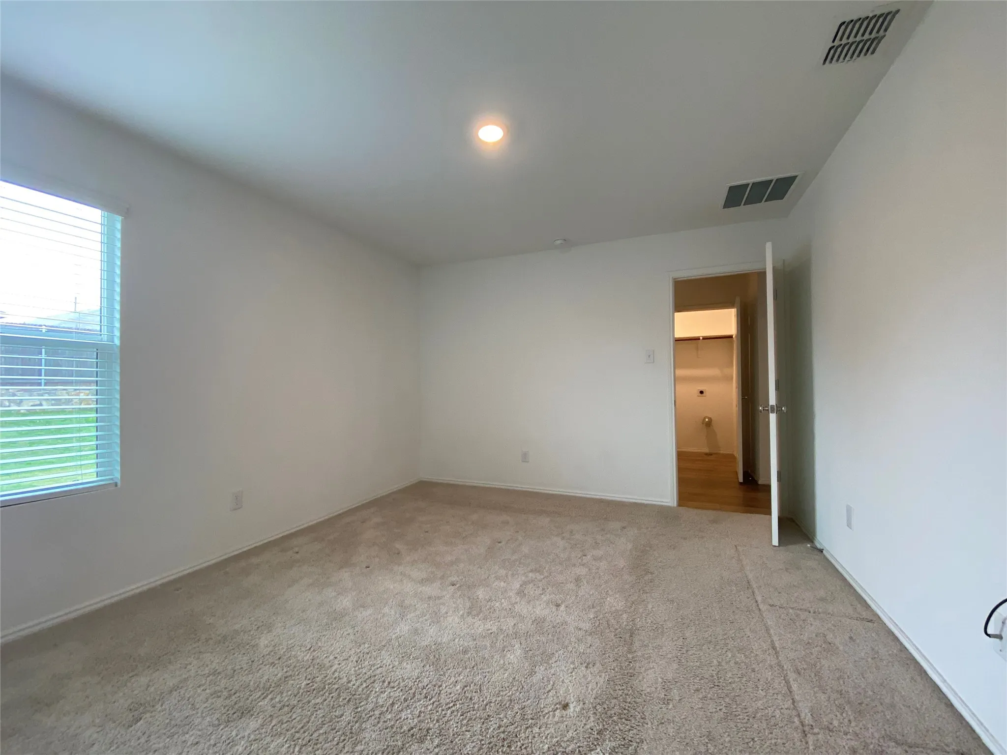Unfurnished room featuring light colored carpet and visible vents