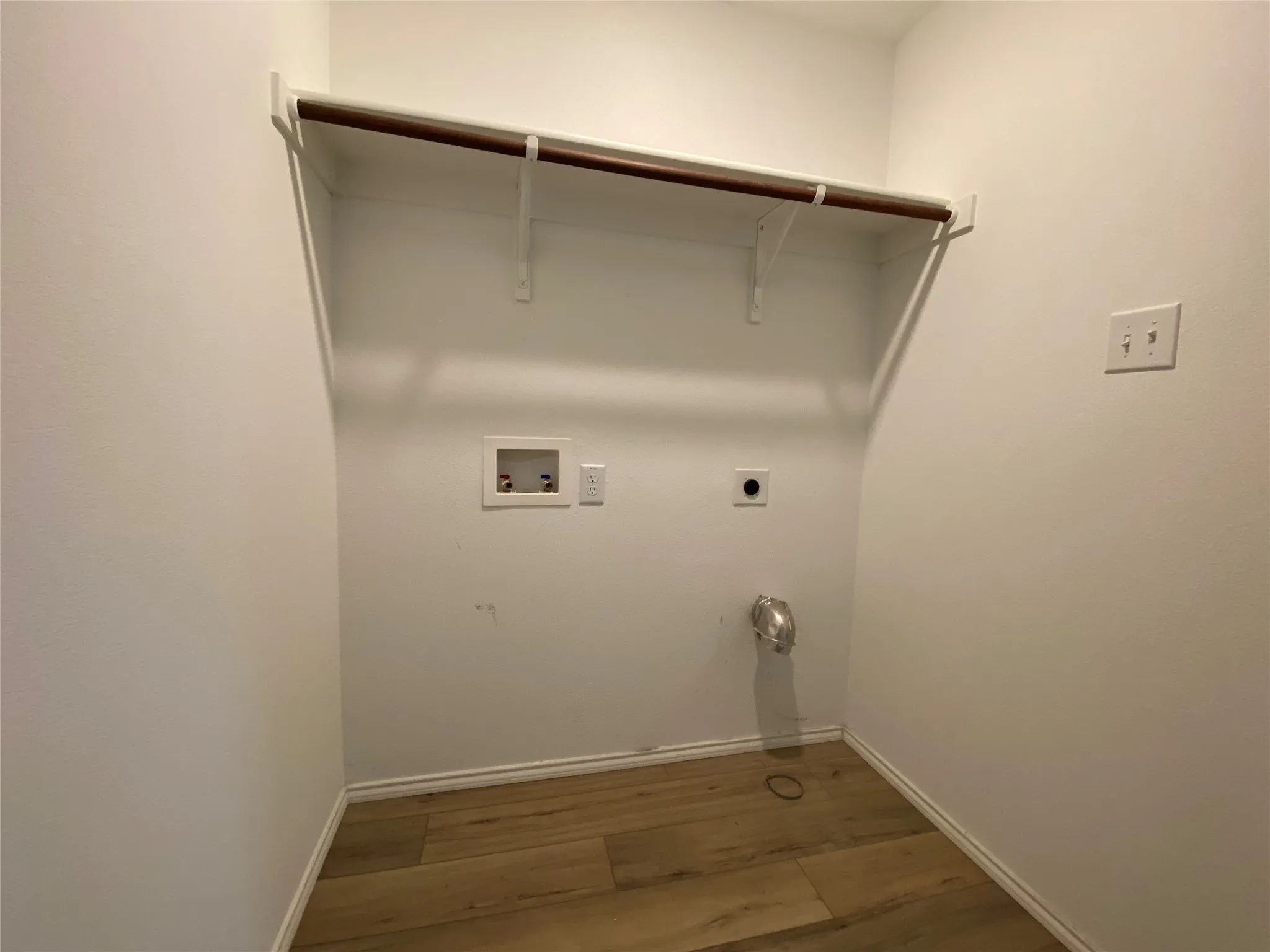 Laundry room with wood finished floors, electric dryer hookup, laundry area, baseboards, and hookup for a washing machine