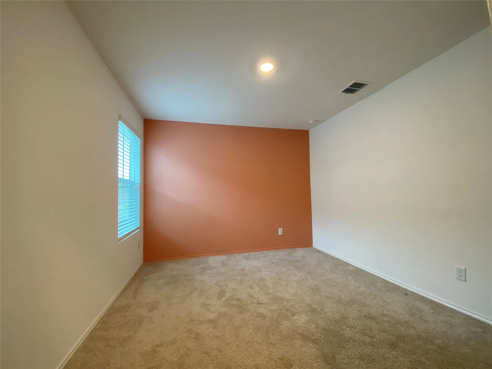 Carpeted empty room featuring baseboards and visible vents