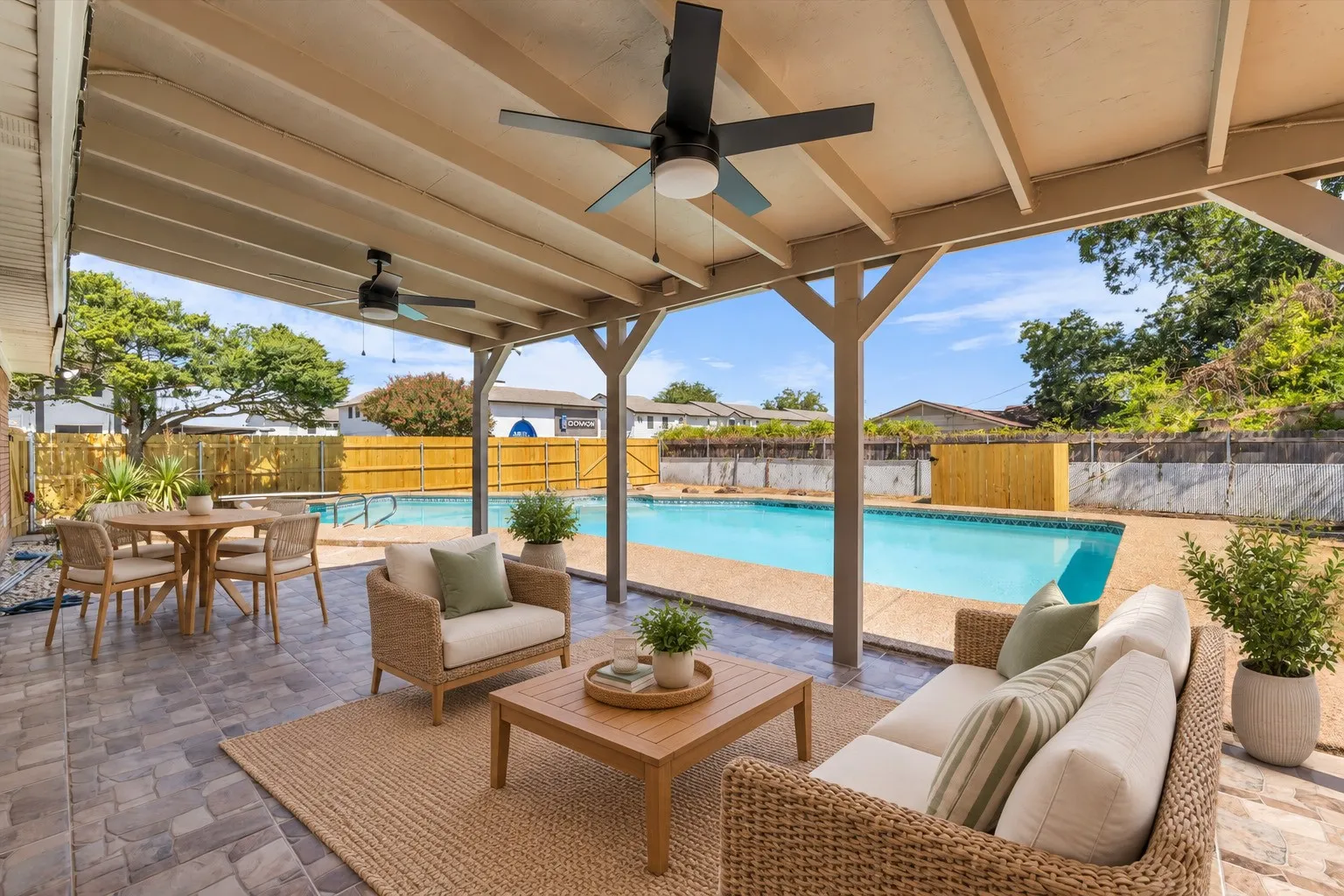 Covered patio featuring an in-ground swimming pool, ceiling fans, and a privacy fence, Virtually Staged