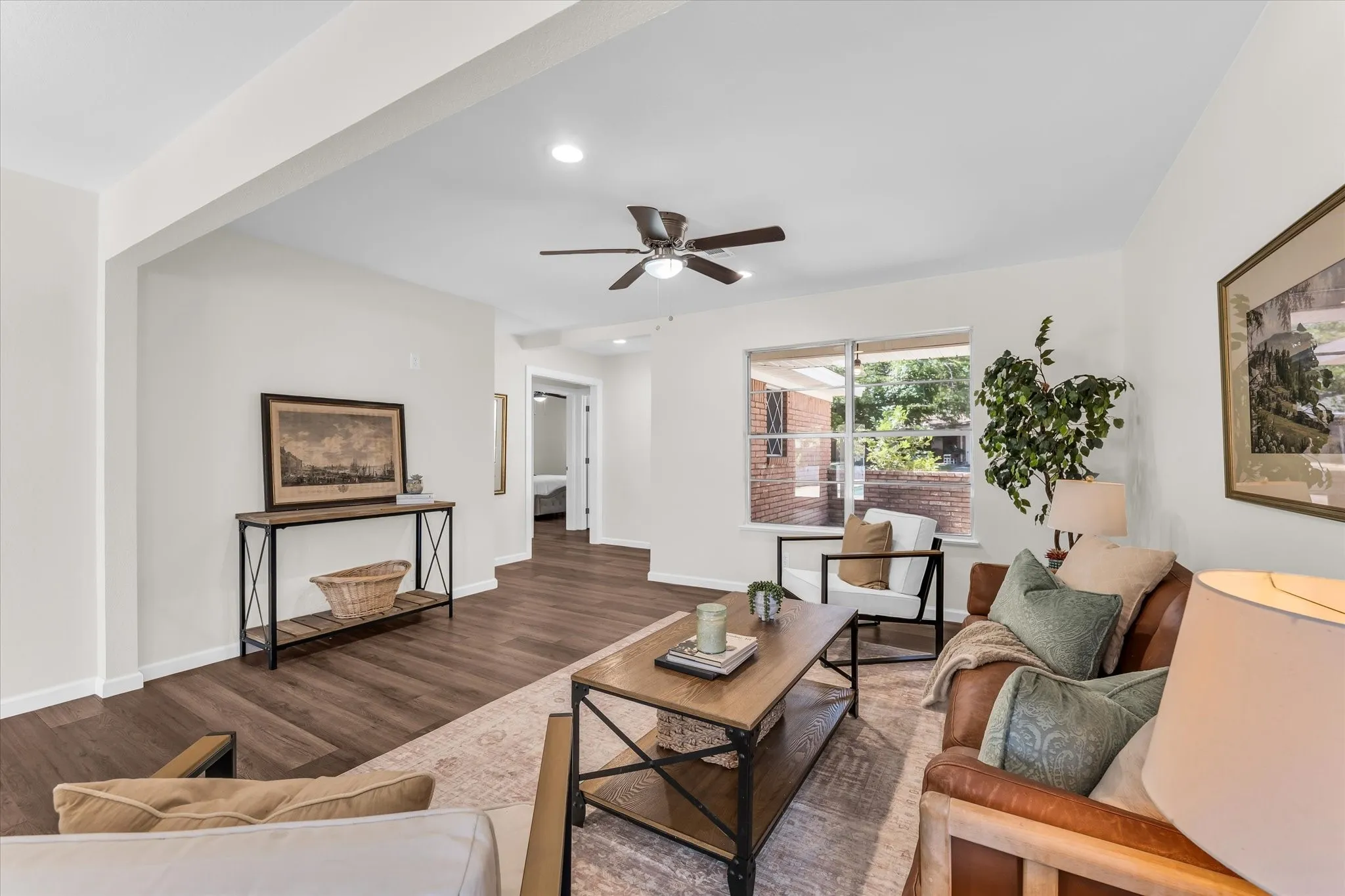 Spacious living area featuring wood-finish flooring, recessed lighting, a ceiling fan, and large windows