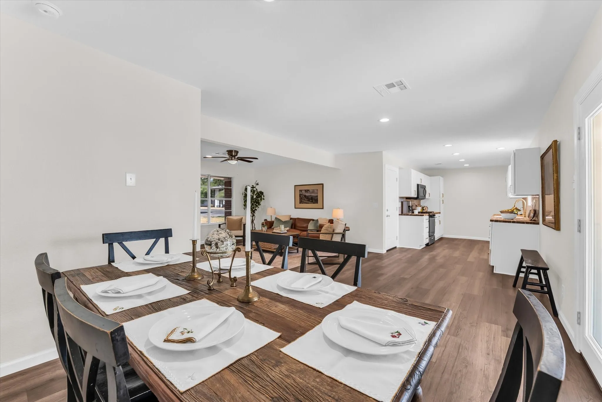 Open-concept dining area with wood-finish flooring, recessed lighting, and white walls