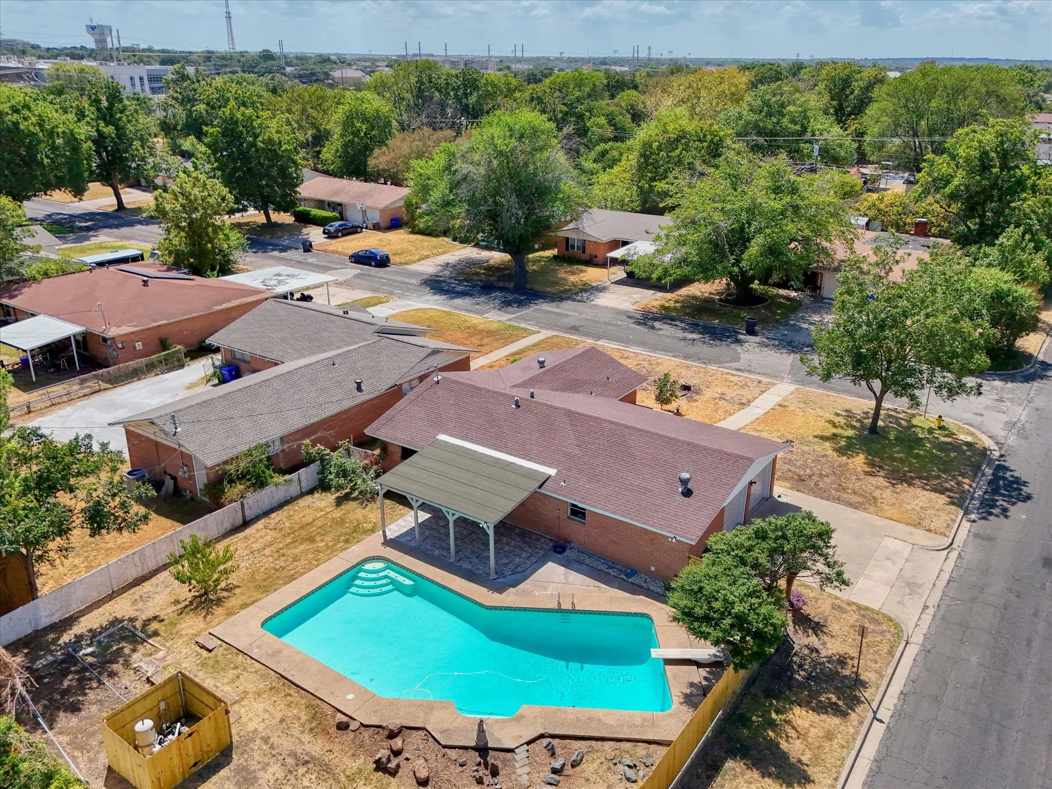 Rear-yard swimming pool with integrated steps, surrounded by a paved deck