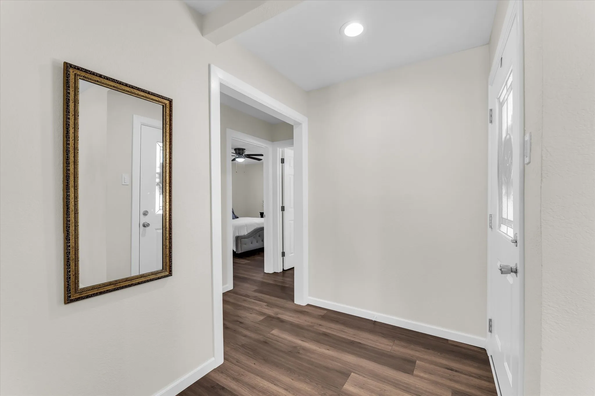 Entryway featuring wood-finish flooring, recessed lighting, and a white paneled door with decorative glass