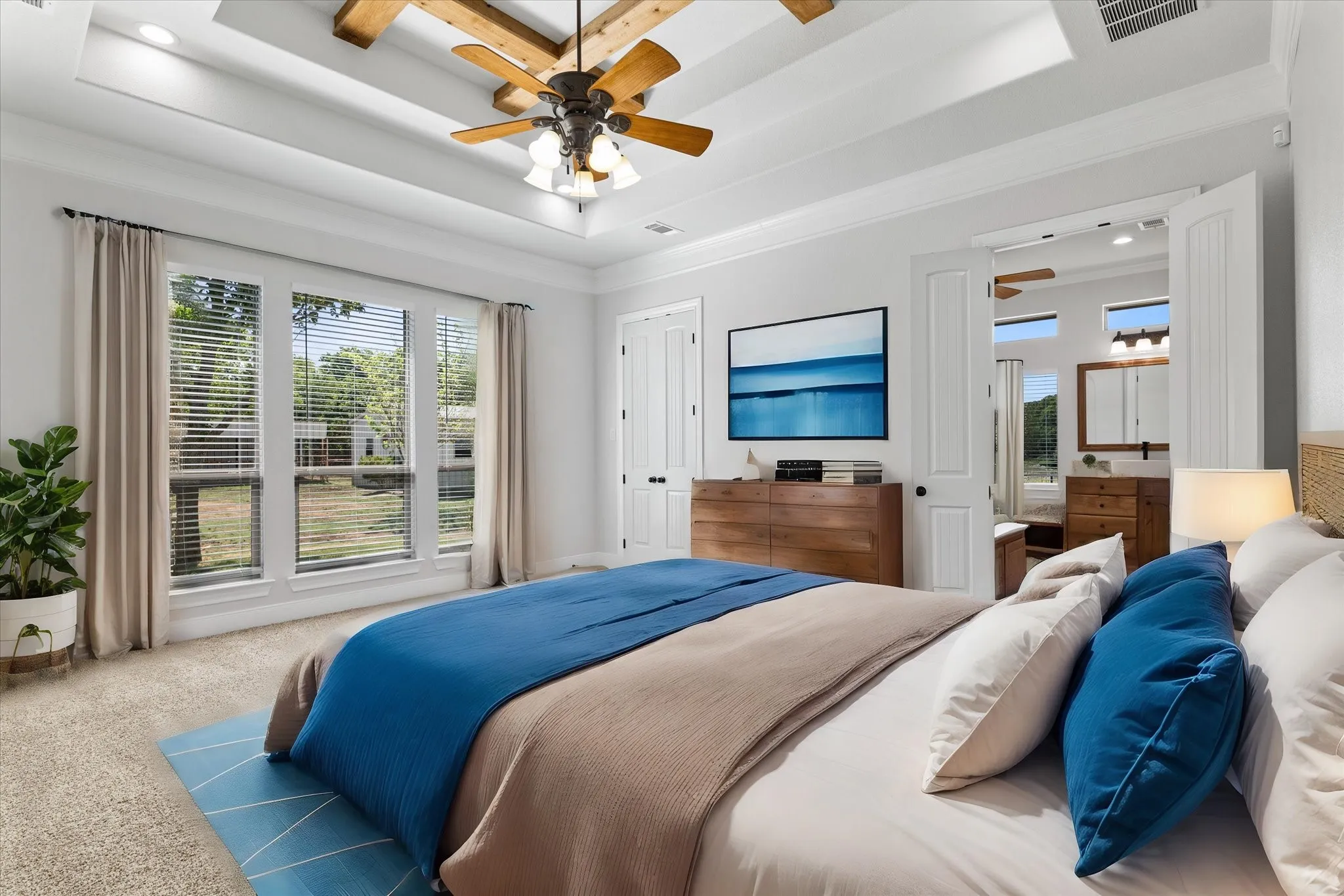 Tray ceiling with wood beam accents and a ceiling fan