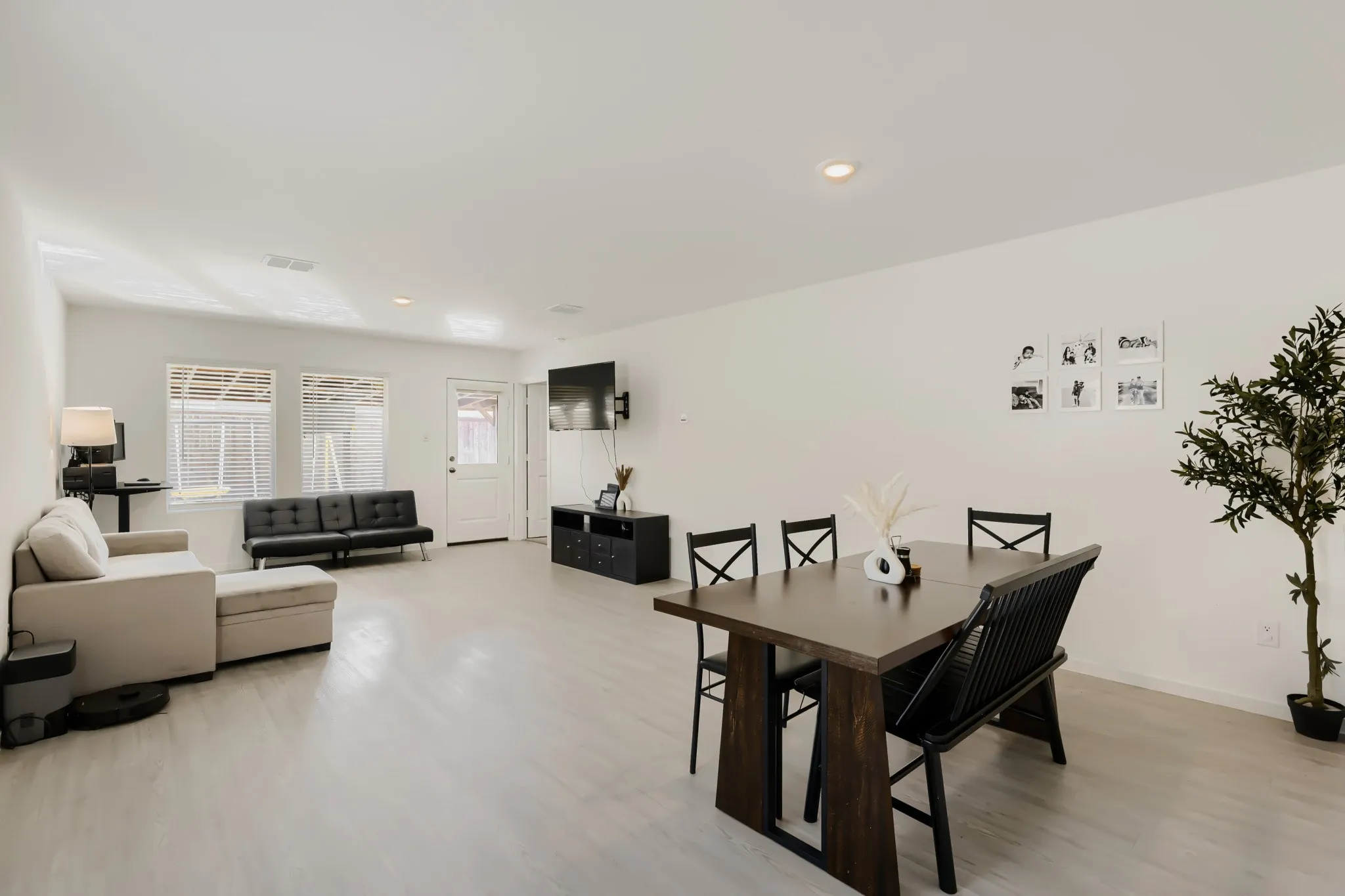 Open-concept living space featuring light-toned wood-finish flooring, recessed lighting, and white walls