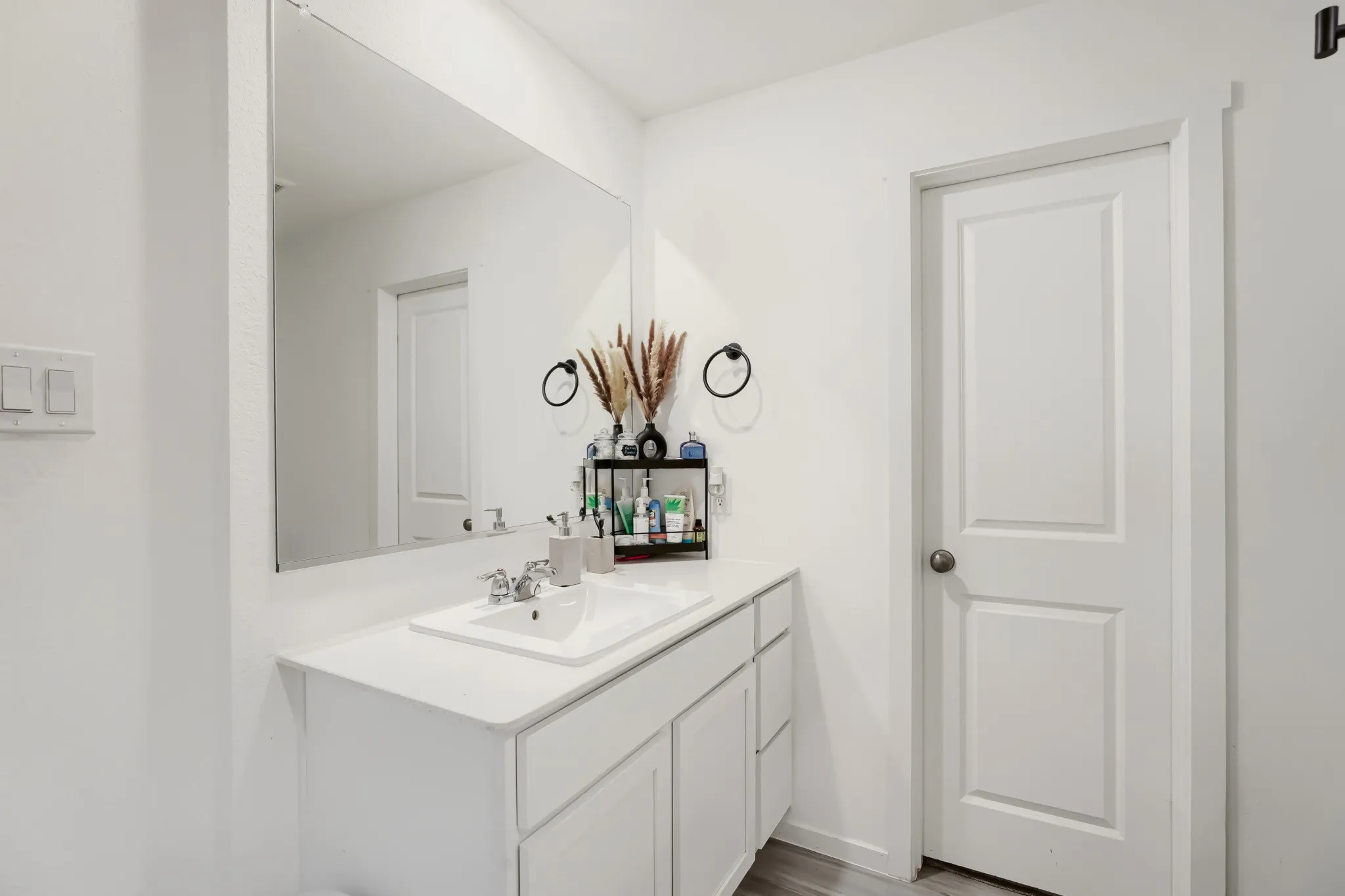 Integrated vanity with white cabinetry, a single basin sink, and a chrome faucet