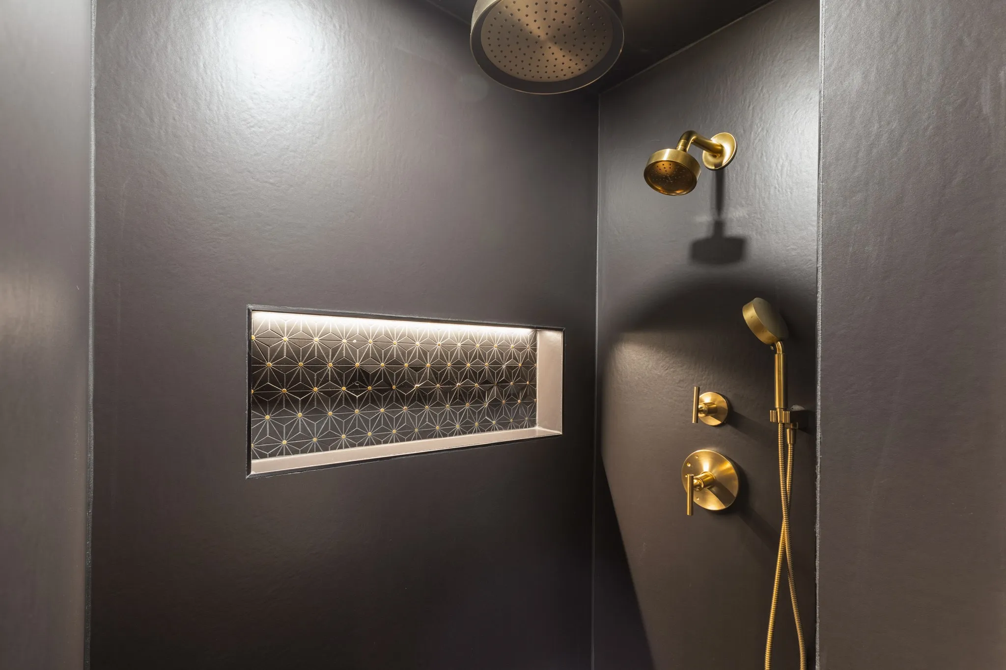 Integrated shower niche with geometric tile and accent lighting