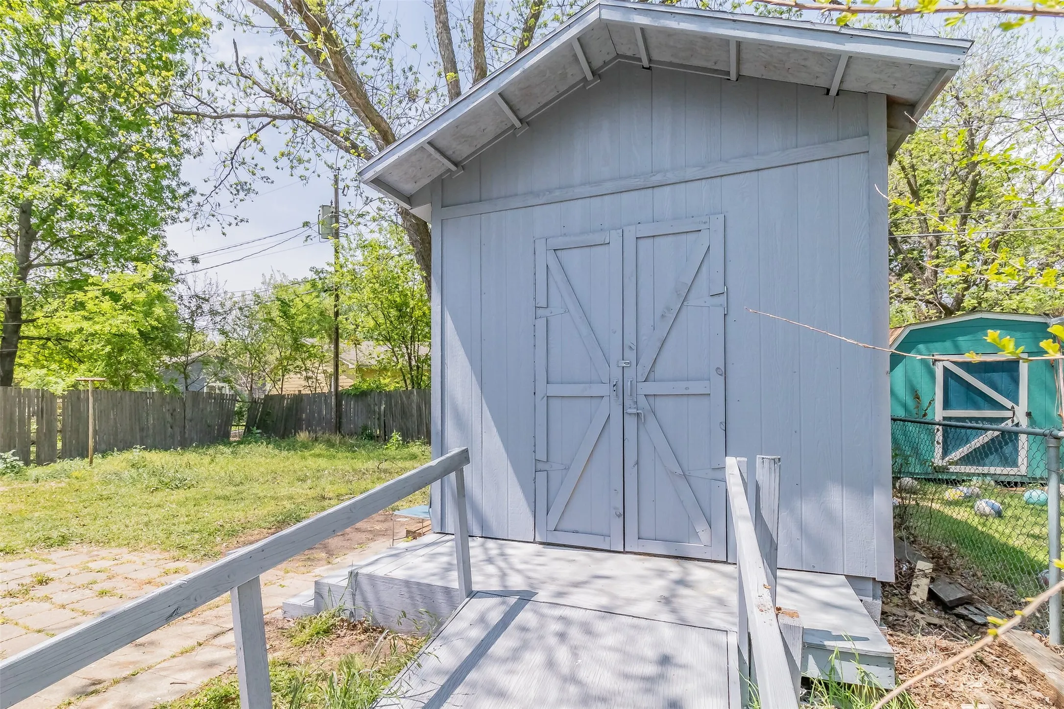 Gable roof storage shed with barn-style double doors and an access ramp