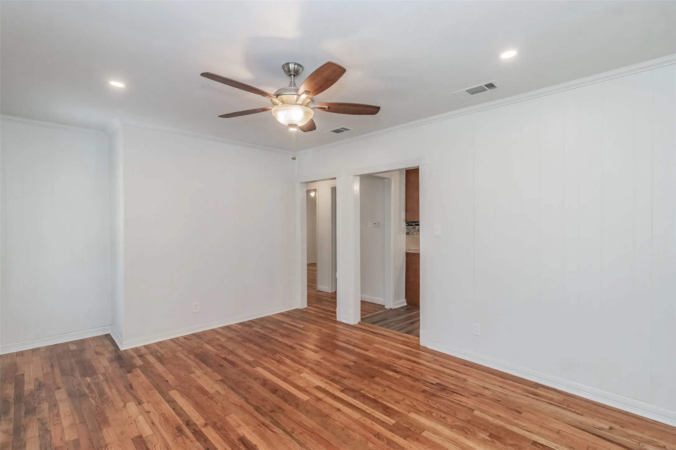 Wood-finish flooring, recessed lighting, and a ceiling fan with integrated light fixture