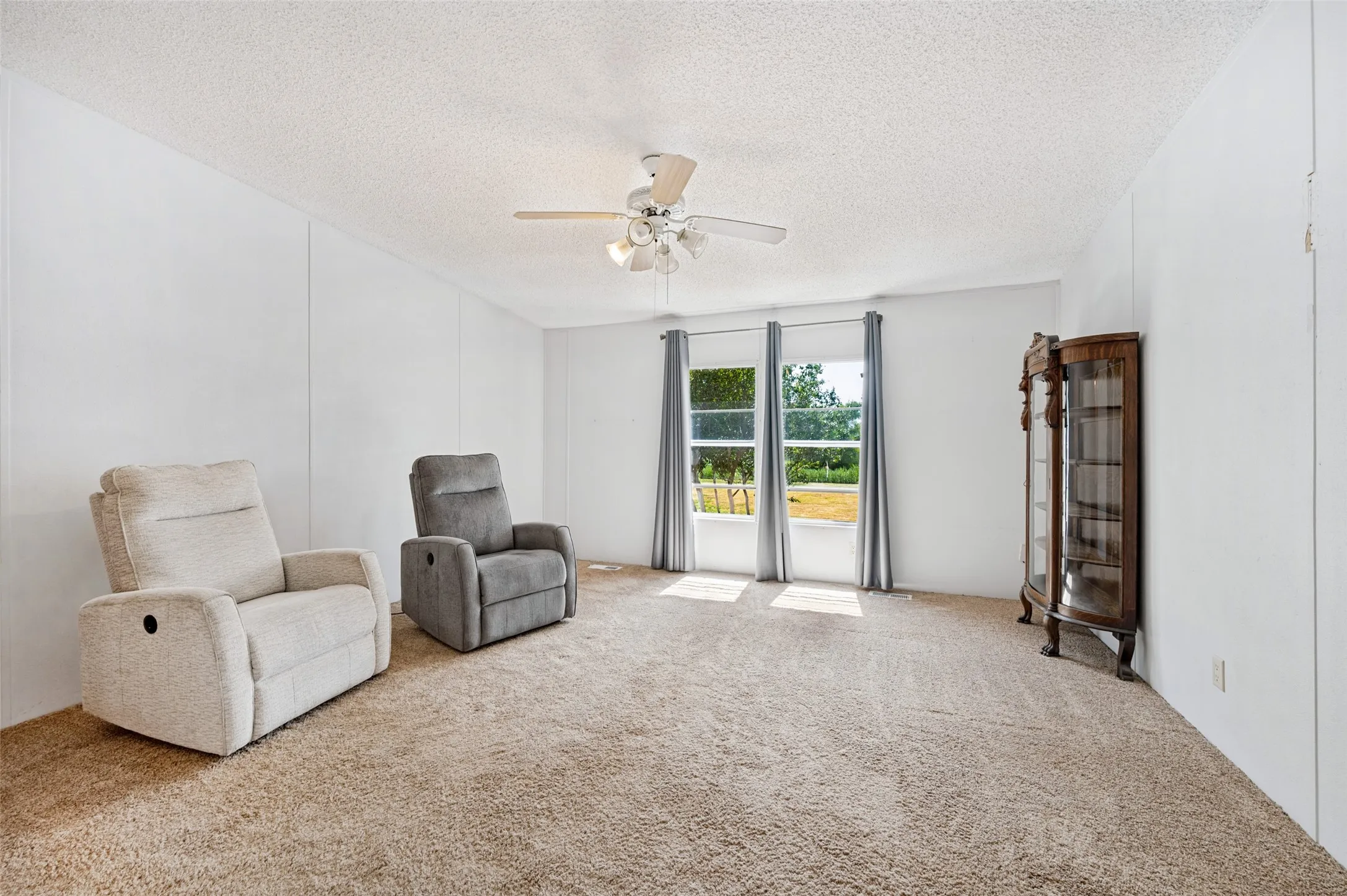 Primary bedroom with nice windows for natural light and carpet.