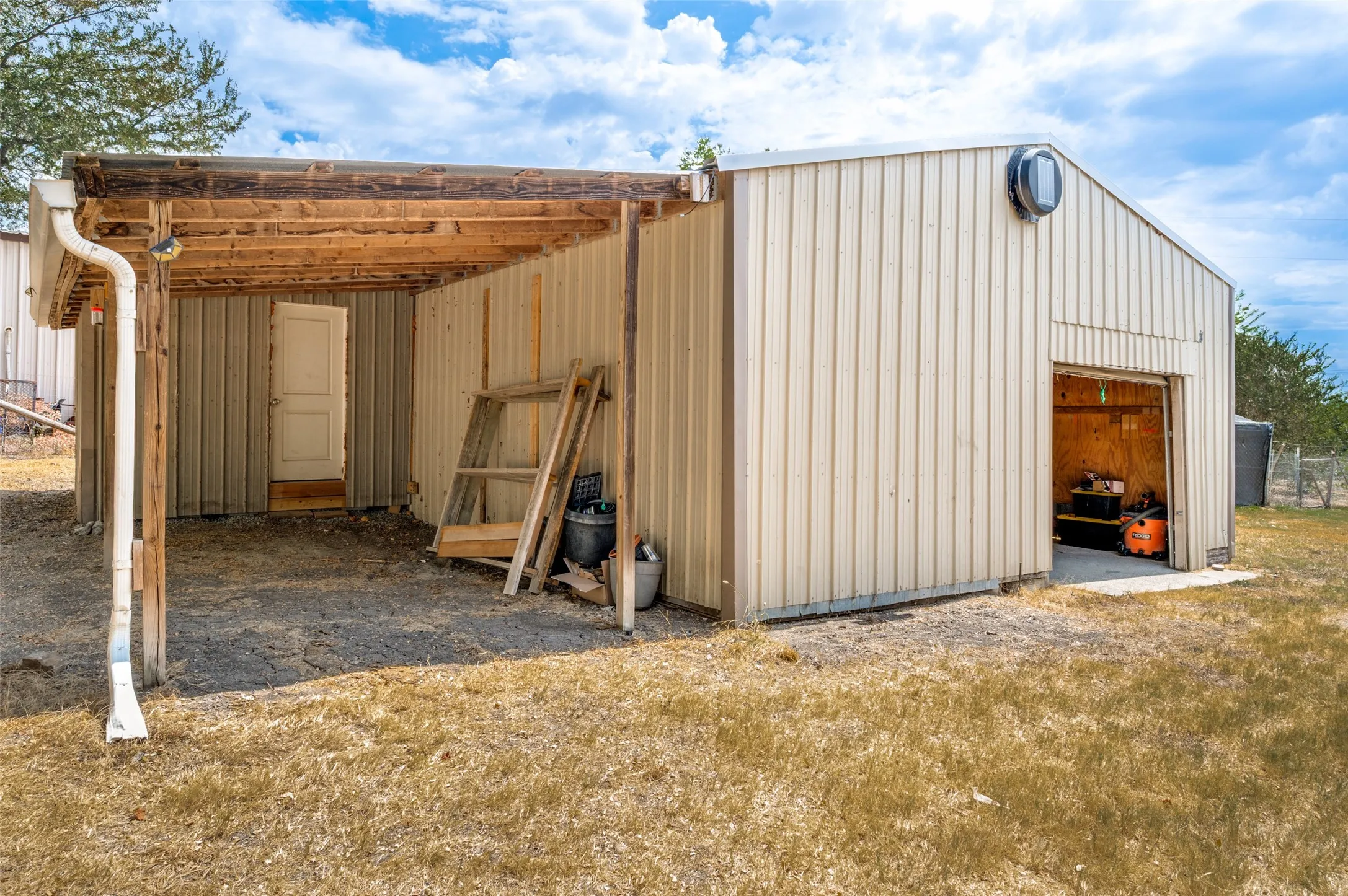 Outside of the workshop  with large 20x10 covered area and storage room with electricity.
