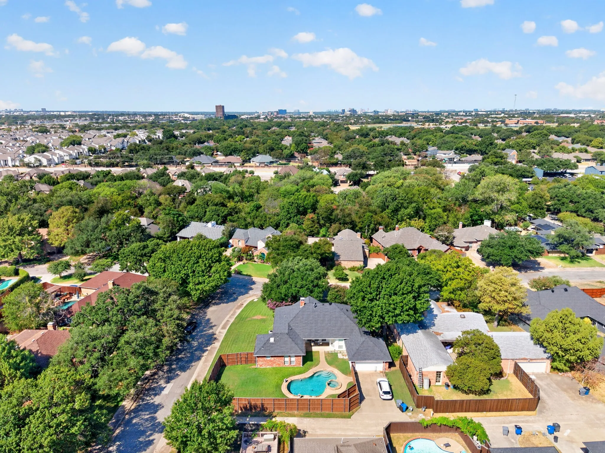 Single-story residence featuring a fenced backyard with an in-ground swimming pool, an attached two-car garage, and mature landscaping