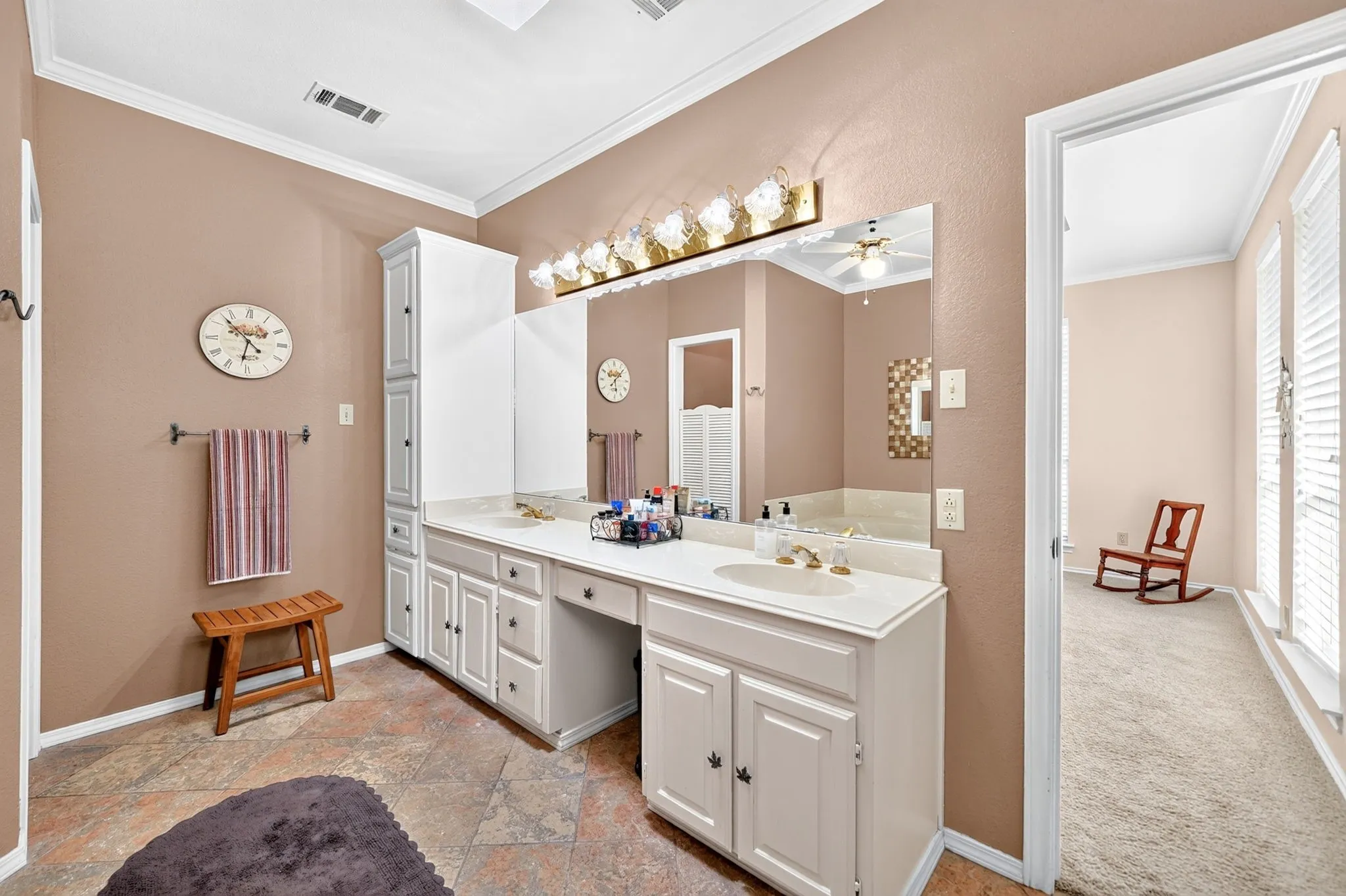 Double vanity with built-in cabinetry, dual sinks, and extensive countertop space