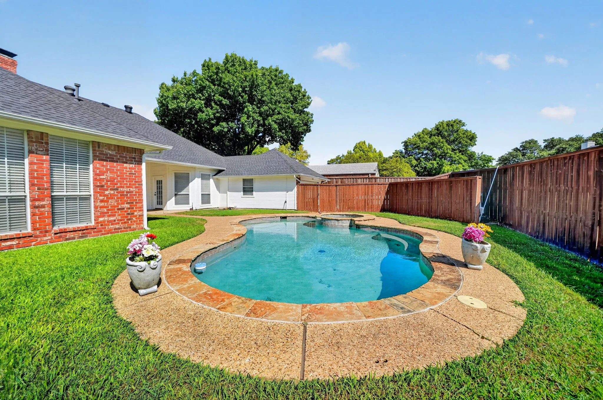 Curved in-ground swimming pool with an integrated spa