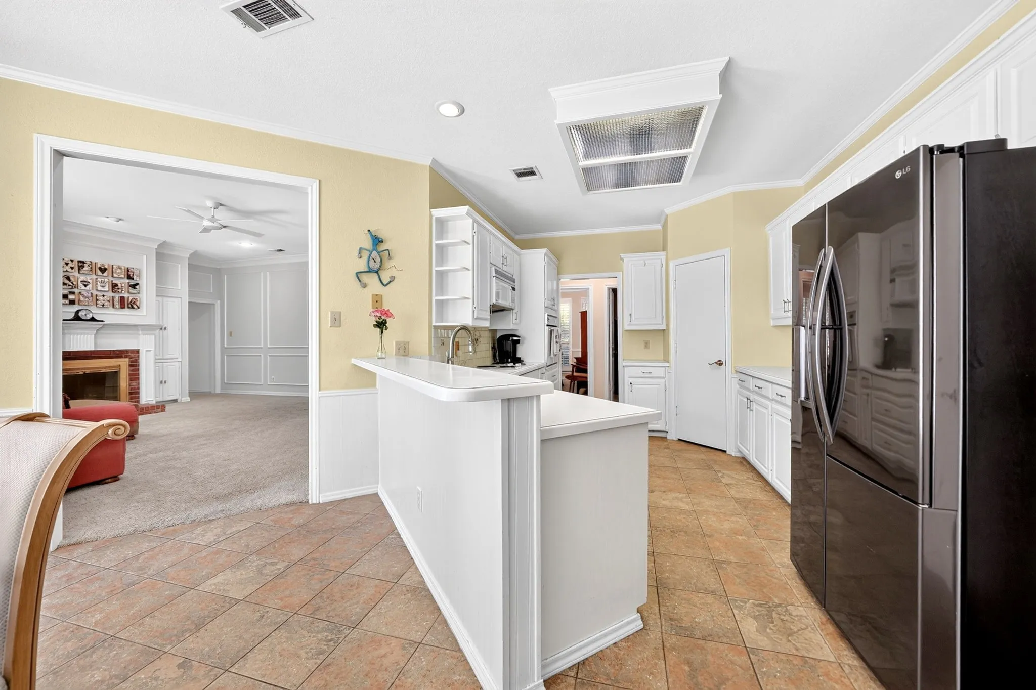 Kitchen featuring white cabinetry, tile flooring, and a breakfast bar