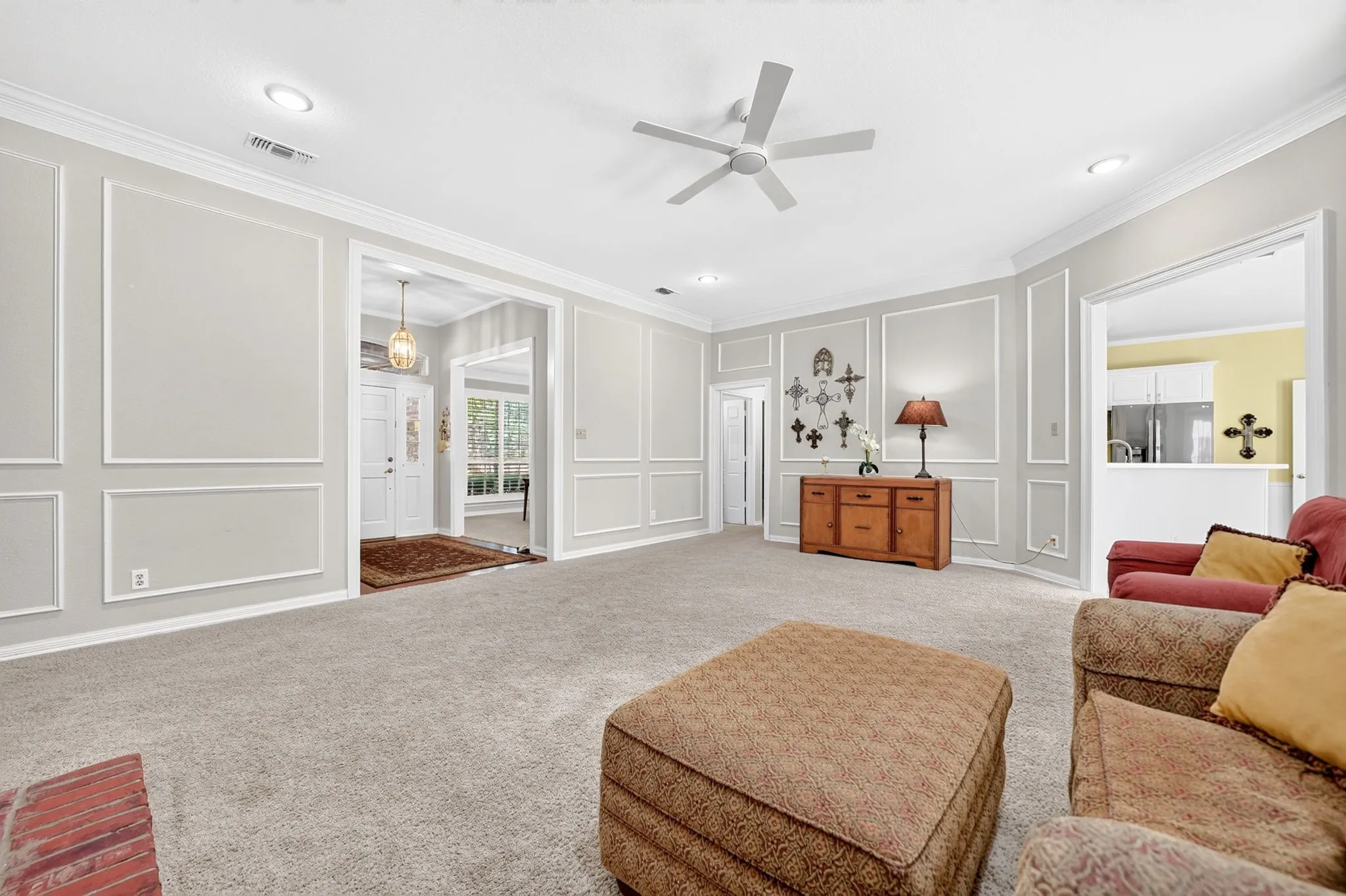 Recessed lighting, crown molding, white ceiling fan, decorative wall molding, and neutral carpeting