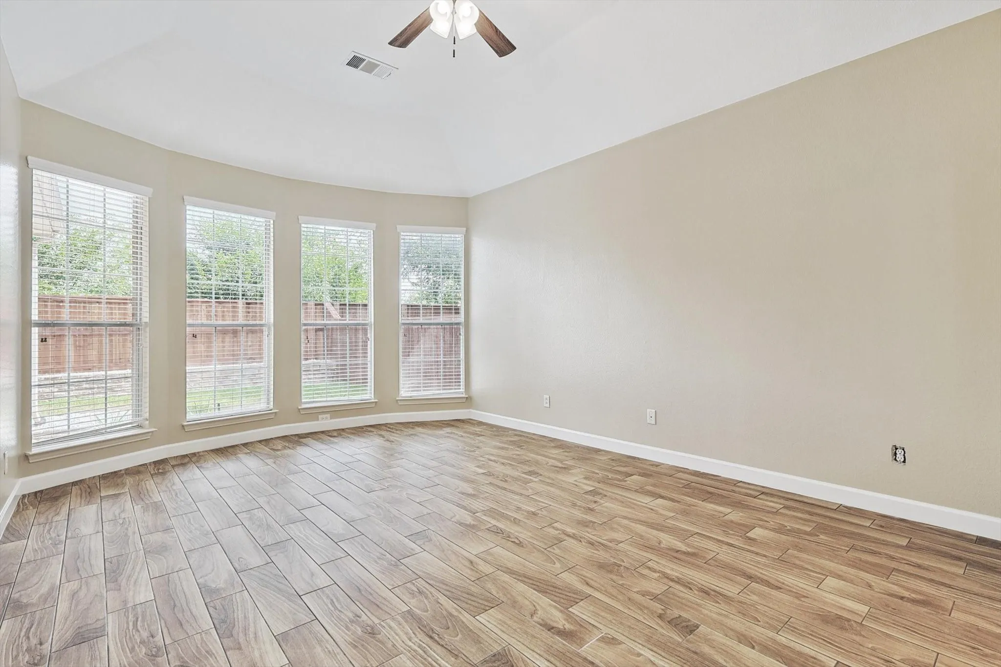 Designed for relaxation, the primary bedroom boasts a wall of windows overlooking the backyard.