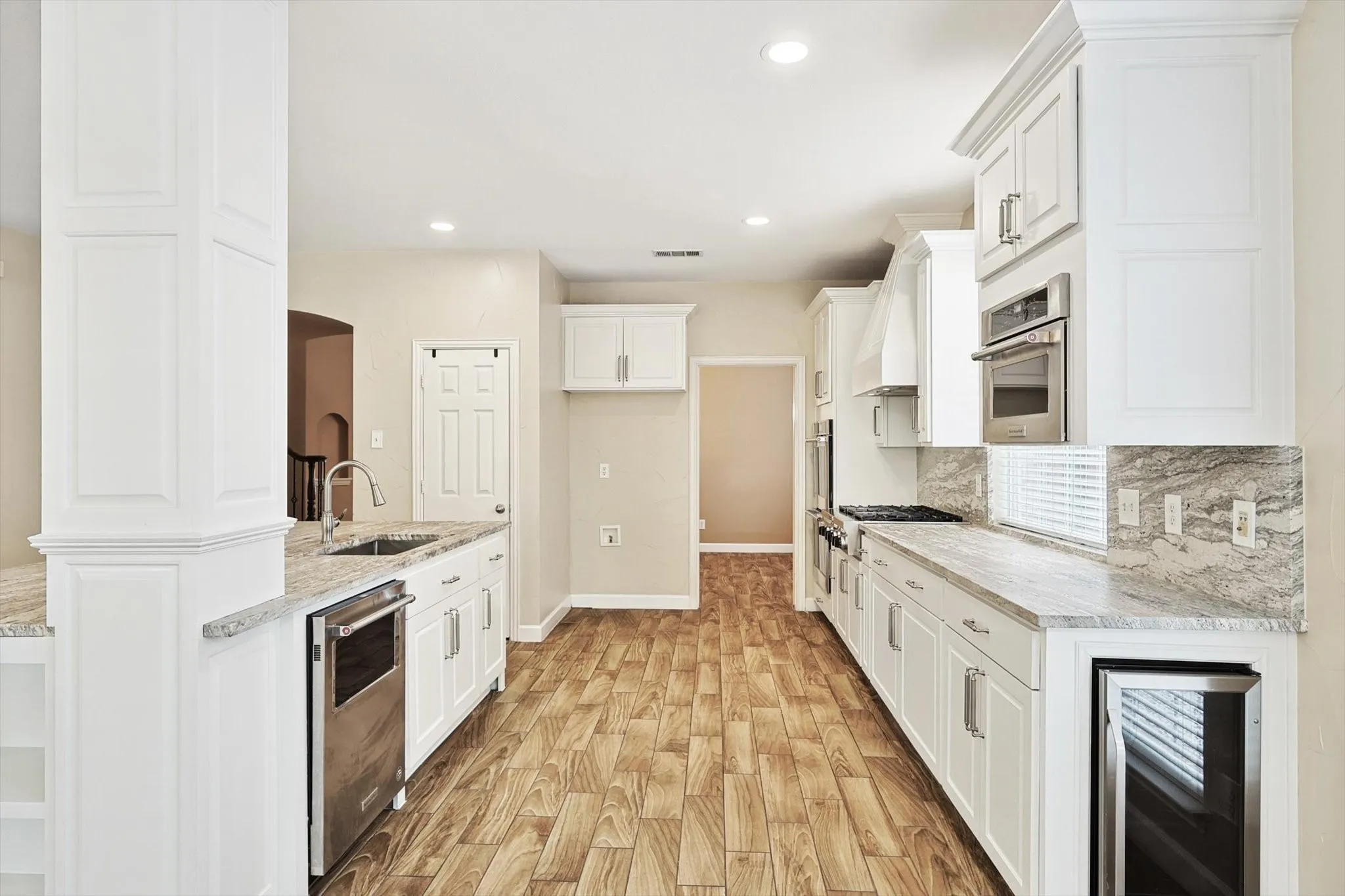 The gourmet kitchen features a wine fridge, an oversized island and abundant storage.