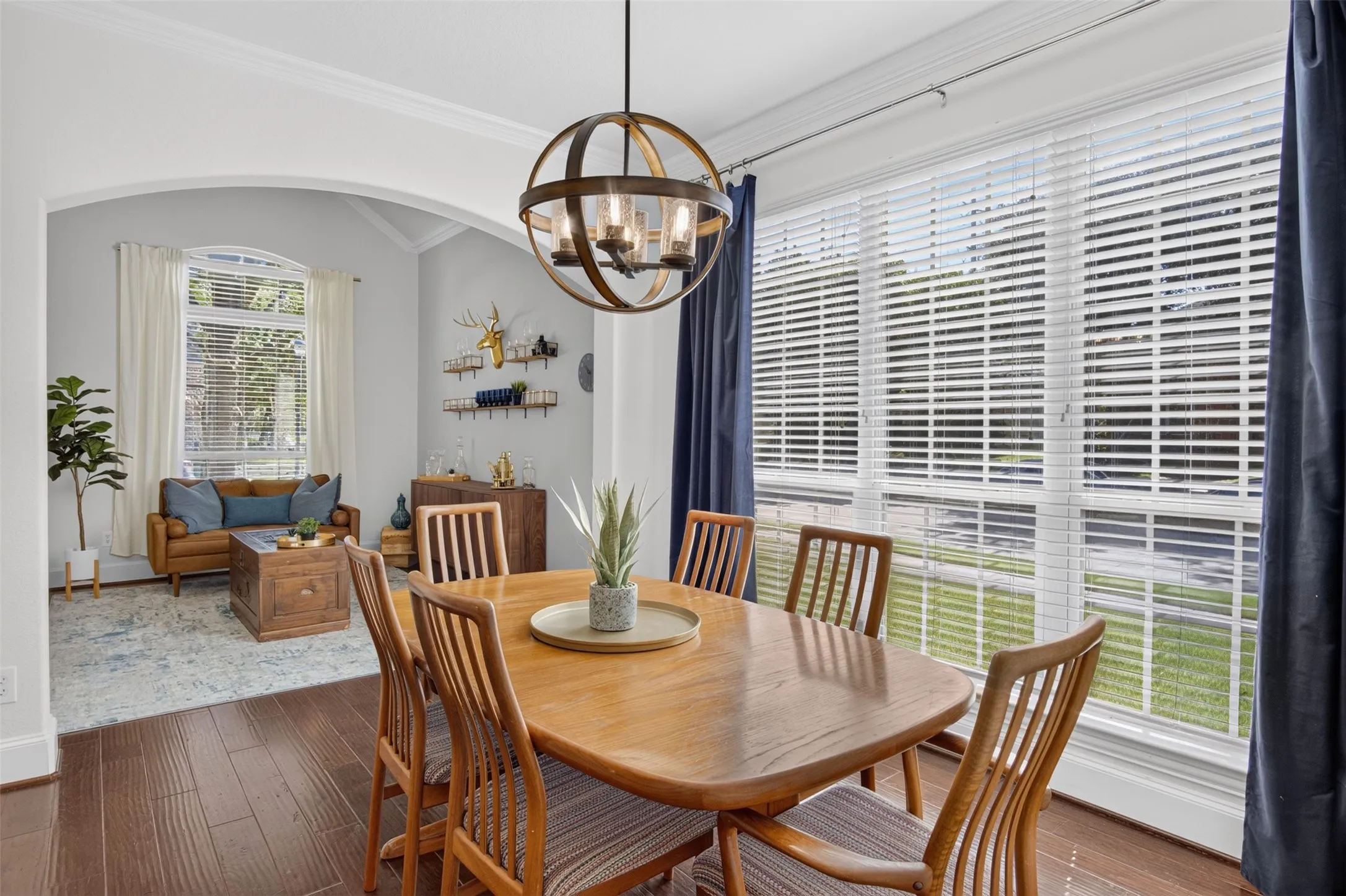 Wood-finish flooring throughout, a large window with blinds, and a contemporary spherical​​‌​​​​‌​​‌‌​‌‌​​​‌‌​‌​‌​‌​​​‌​​ chandelier