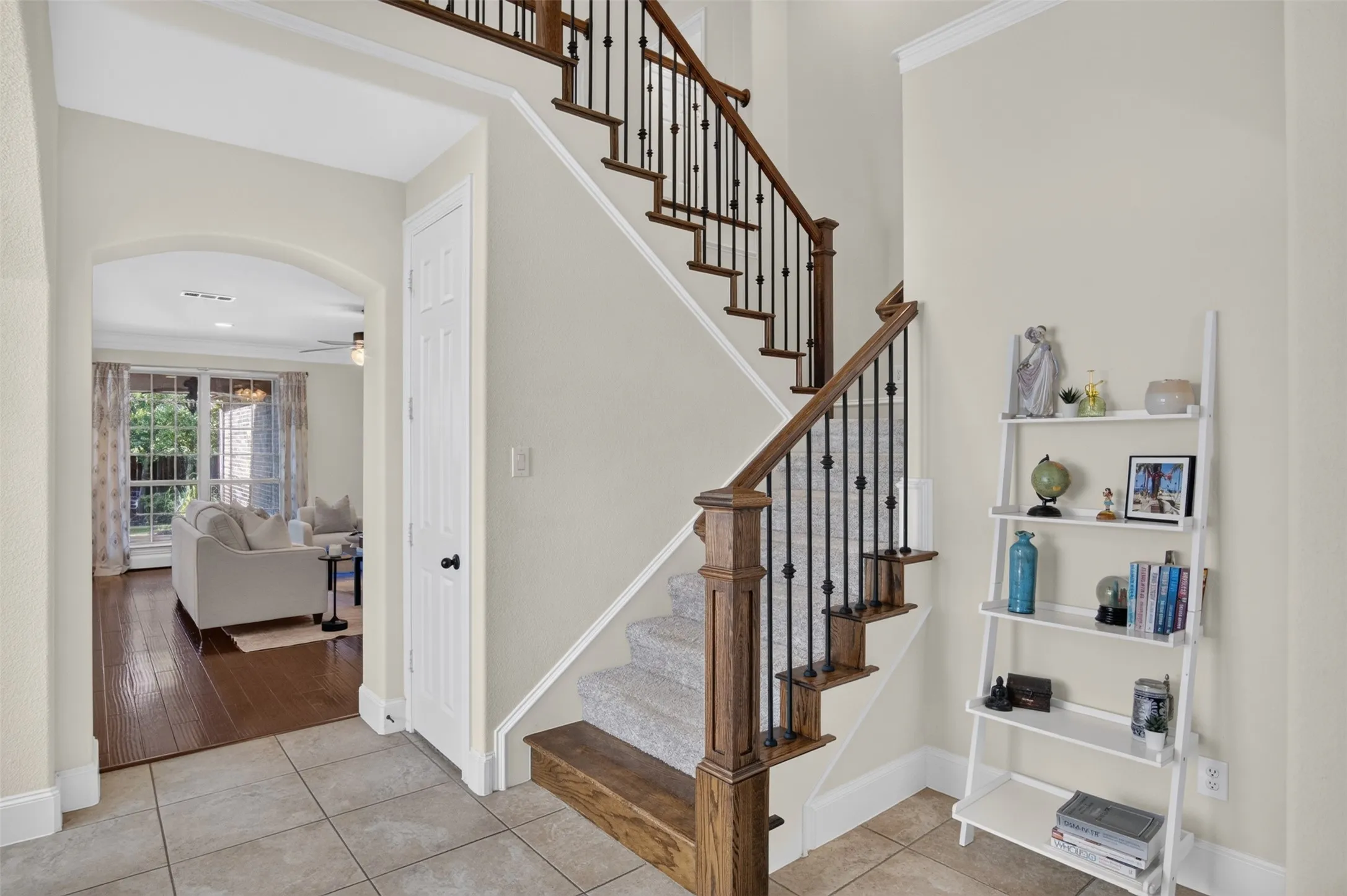 Staircase with wood newel posts, iron balusters, and carpeted treads