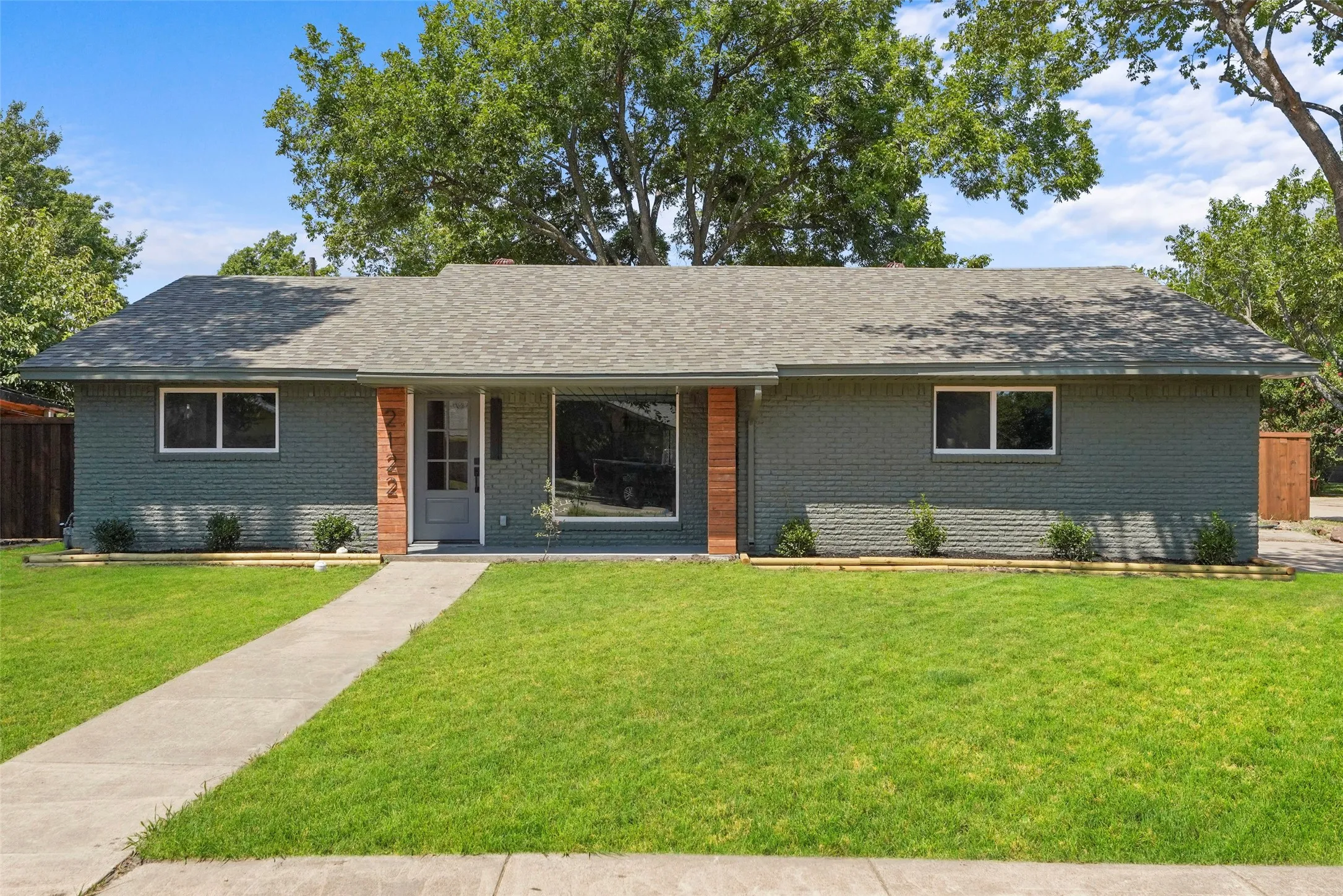 Brick exterior, covered entry, front walkway, and mature landscaping