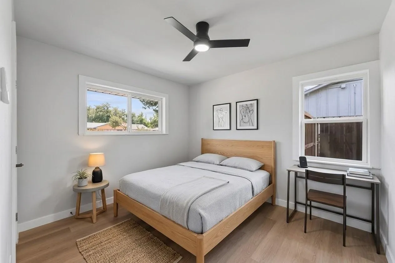 Wood-finish flooring, white walls, and a contemporary ceiling fan with integrated lighting