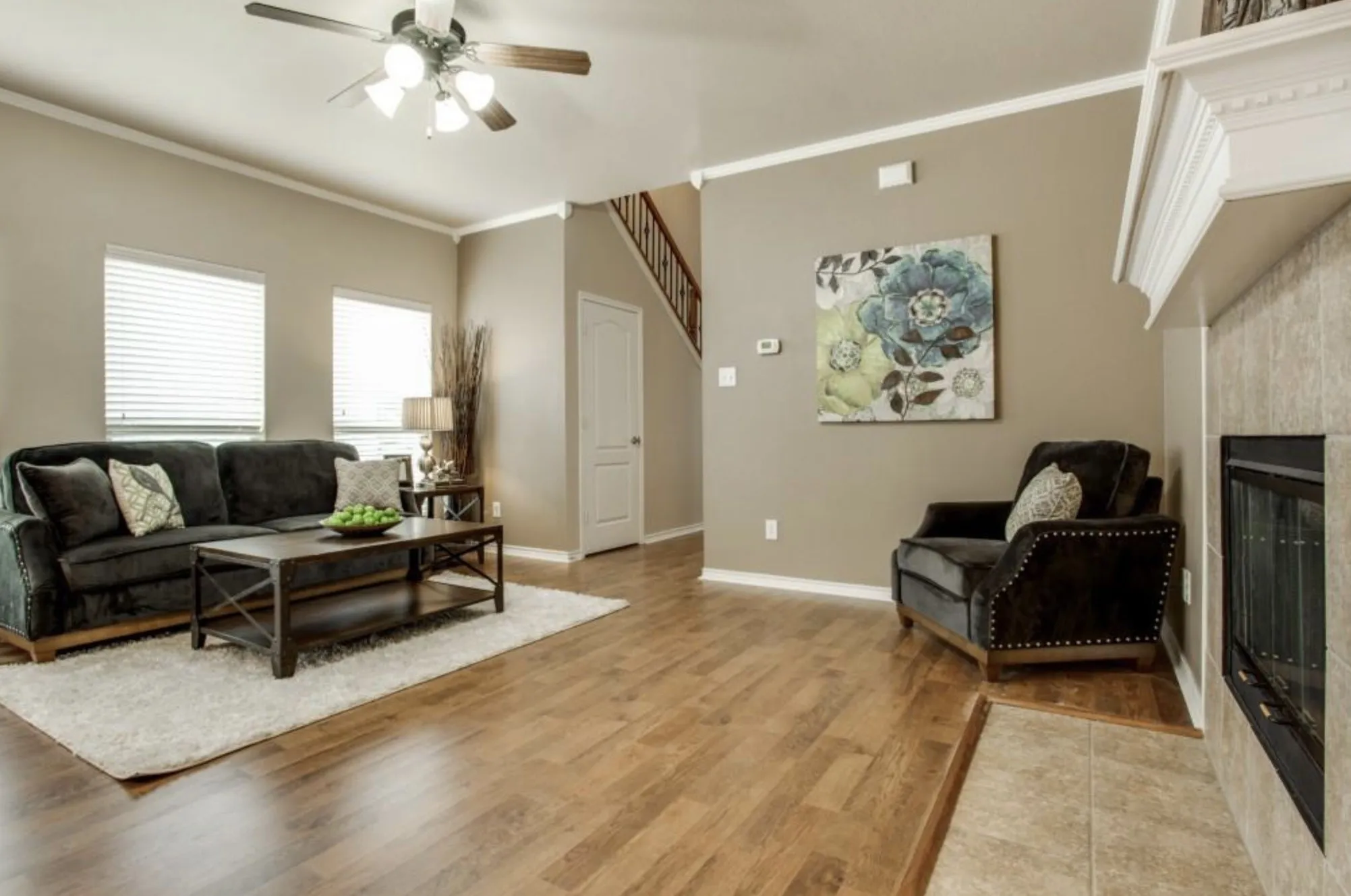 Wood-finish flooring throughout, complemented by crown molding and a ceiling fan