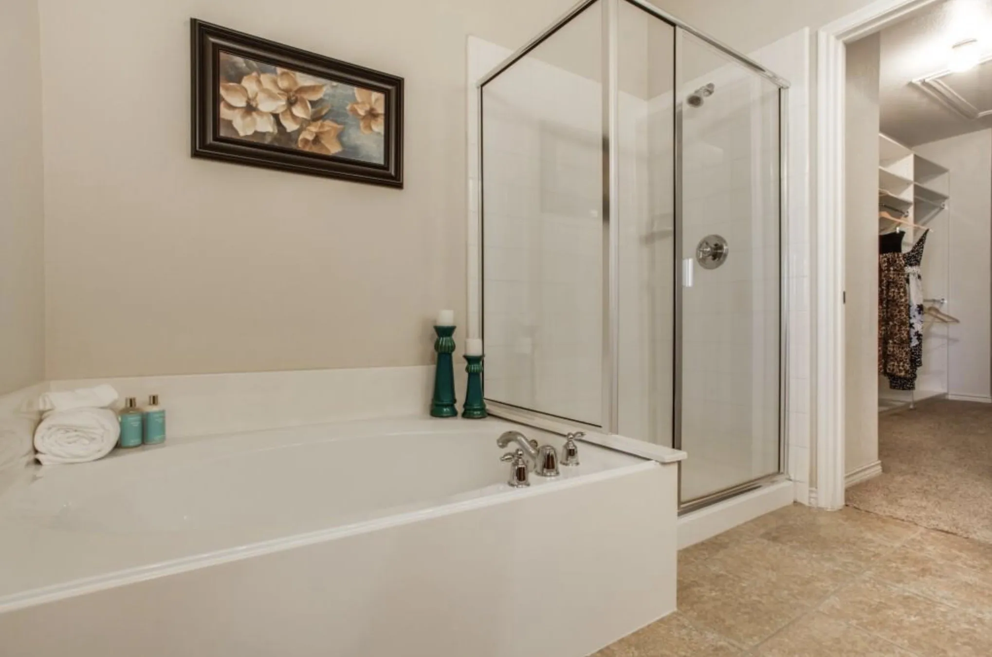 Built-in soaking tub with chrome fixtures, glass-enclosed shower, and neutral wall paint