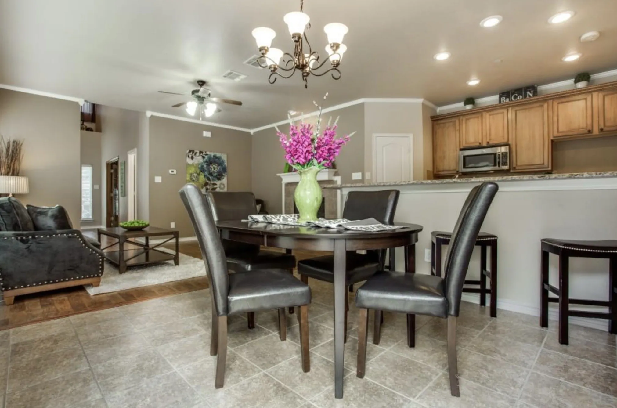 Kitchen with wood cabinetry, stainless steel microwave, and recessed lighting