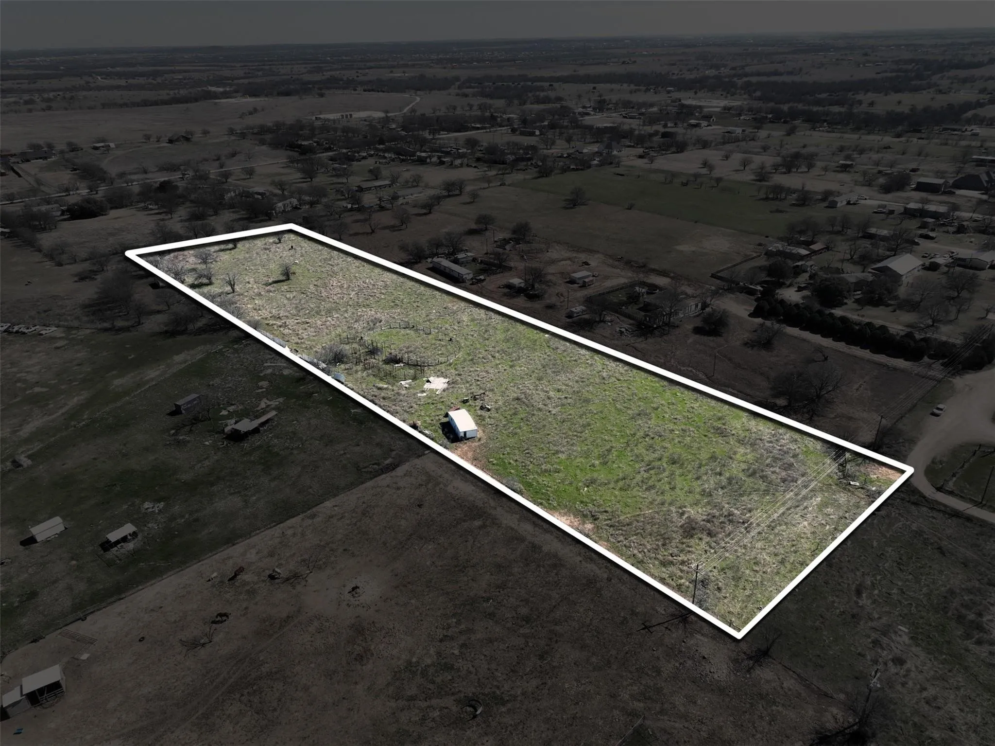 Expansive land parcel featuring open terrain and a utility structure