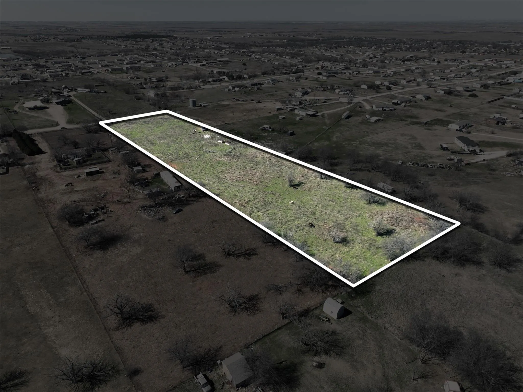Expansive rectangular lot featuring varied terrain and scattered vegetation