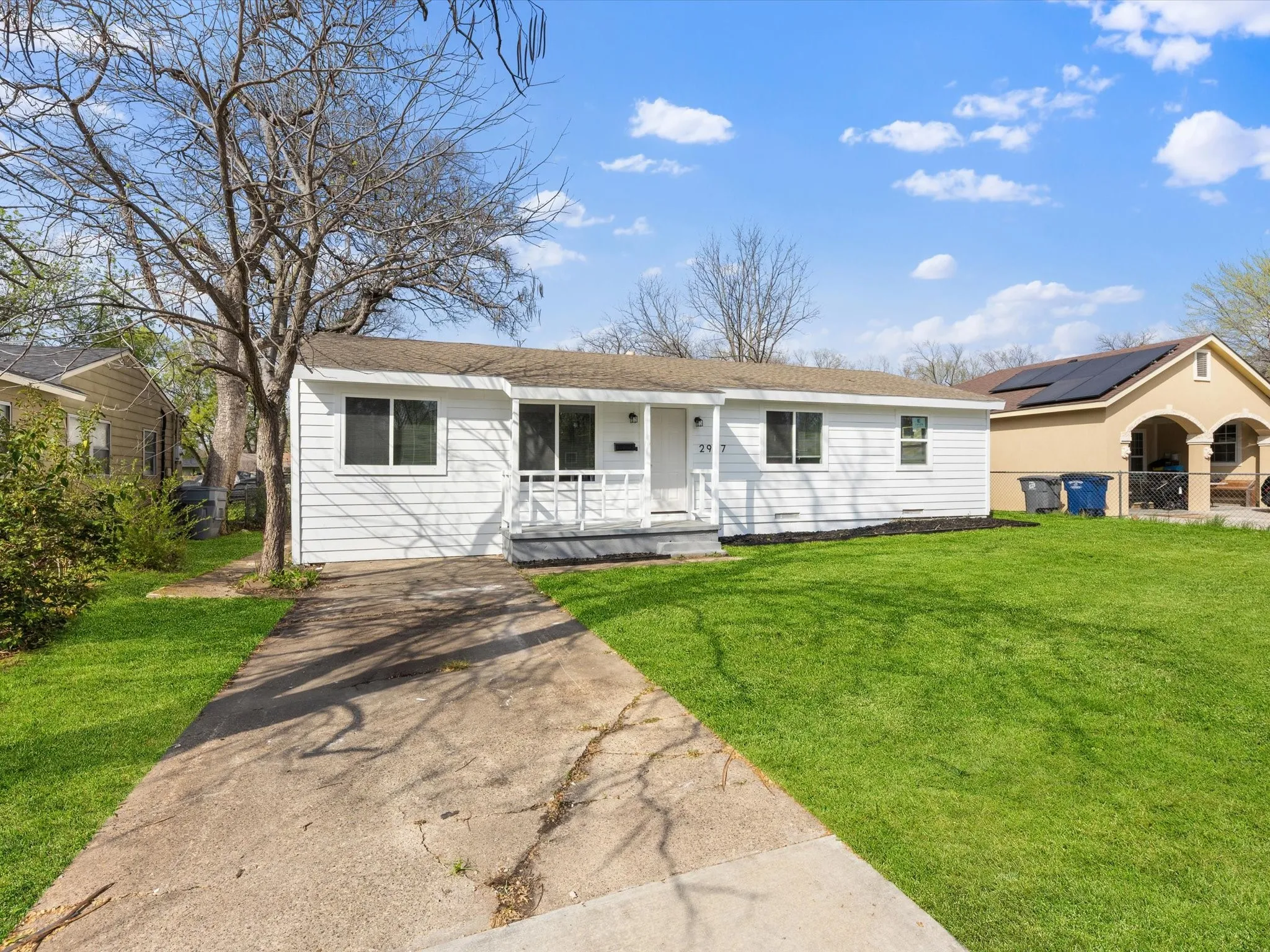 White siding exterior with a covered porch and front yard