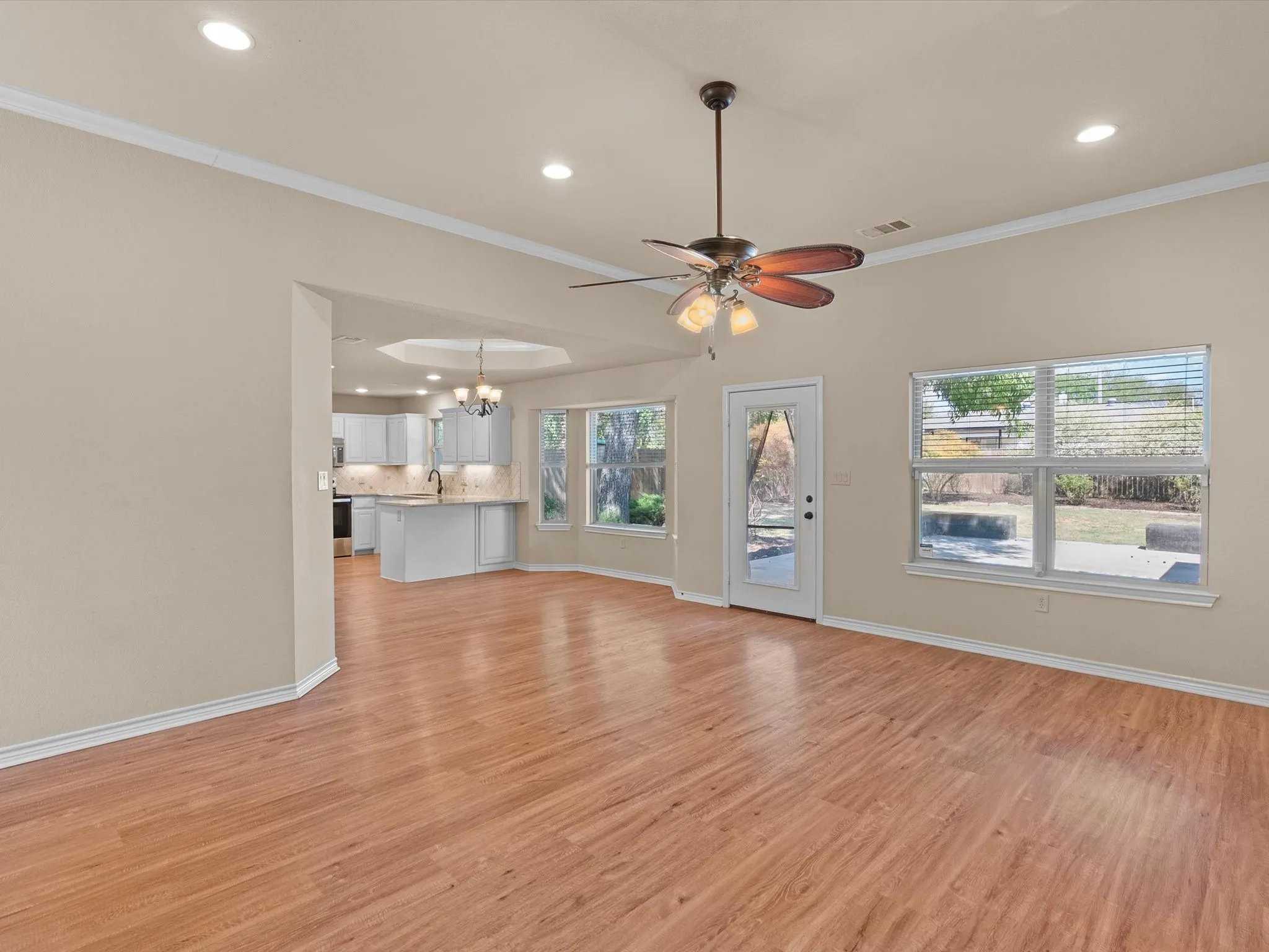 Wood-finish flooring, recessed lighting, and a ceiling fan with light fixture