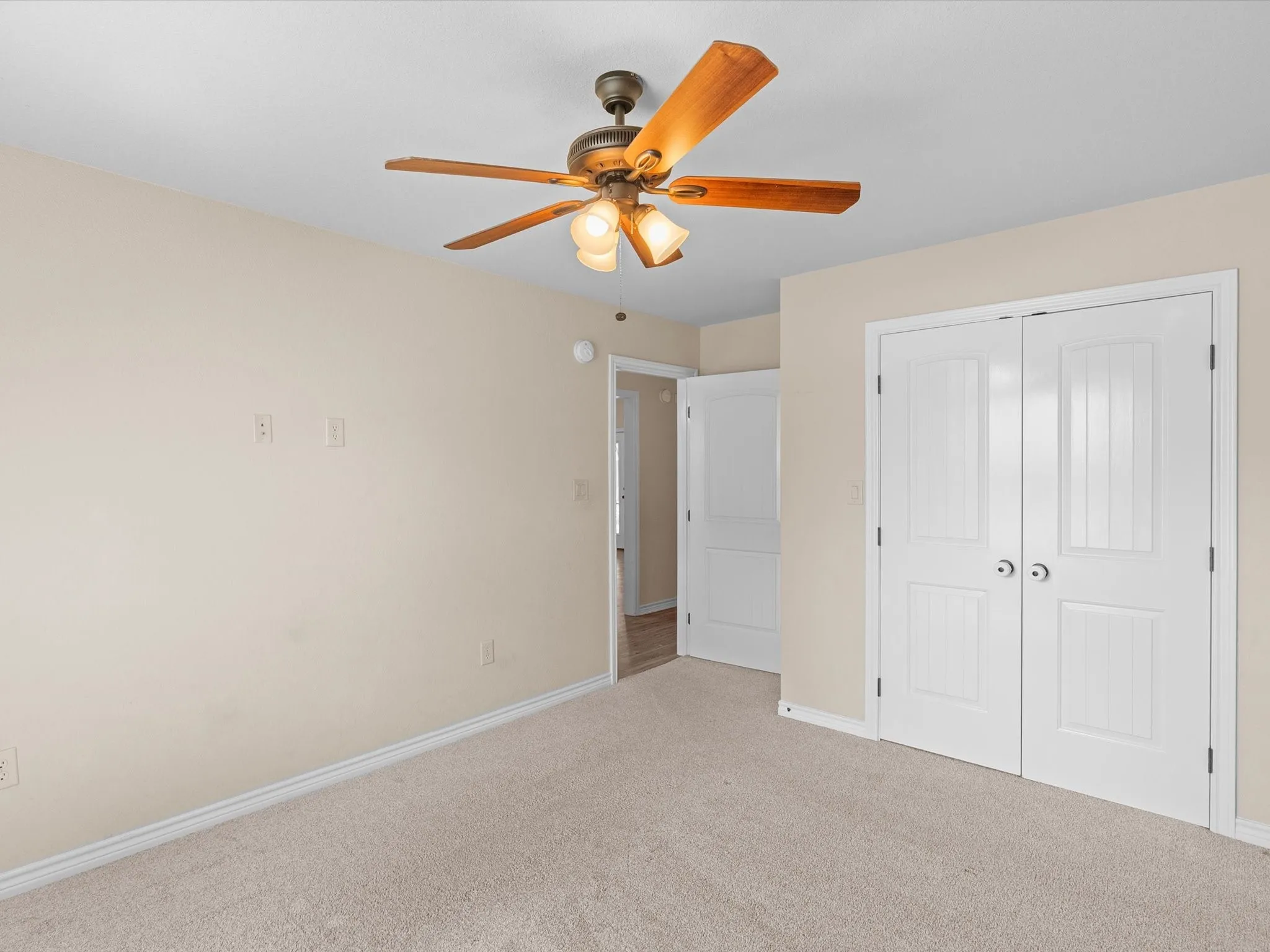 Recessed lighting, wood-finish ceiling fan, neutral wall paint, carpeted flooring, and white bi-fold doors