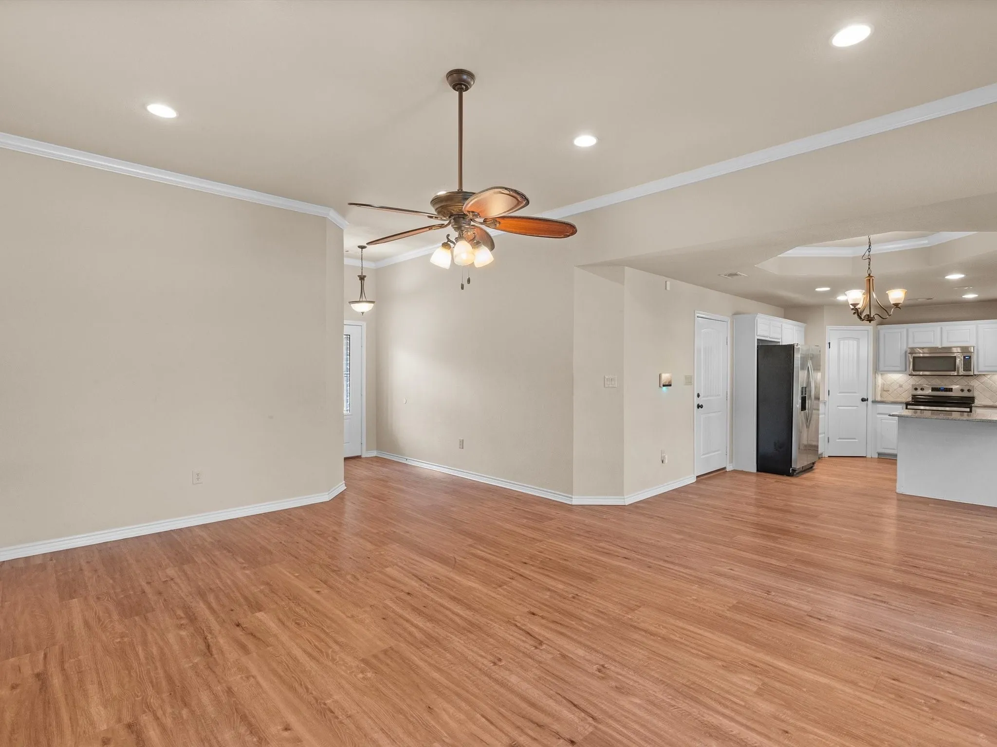 Wood-finish flooring throughout, recessed lighting, and crown molding
