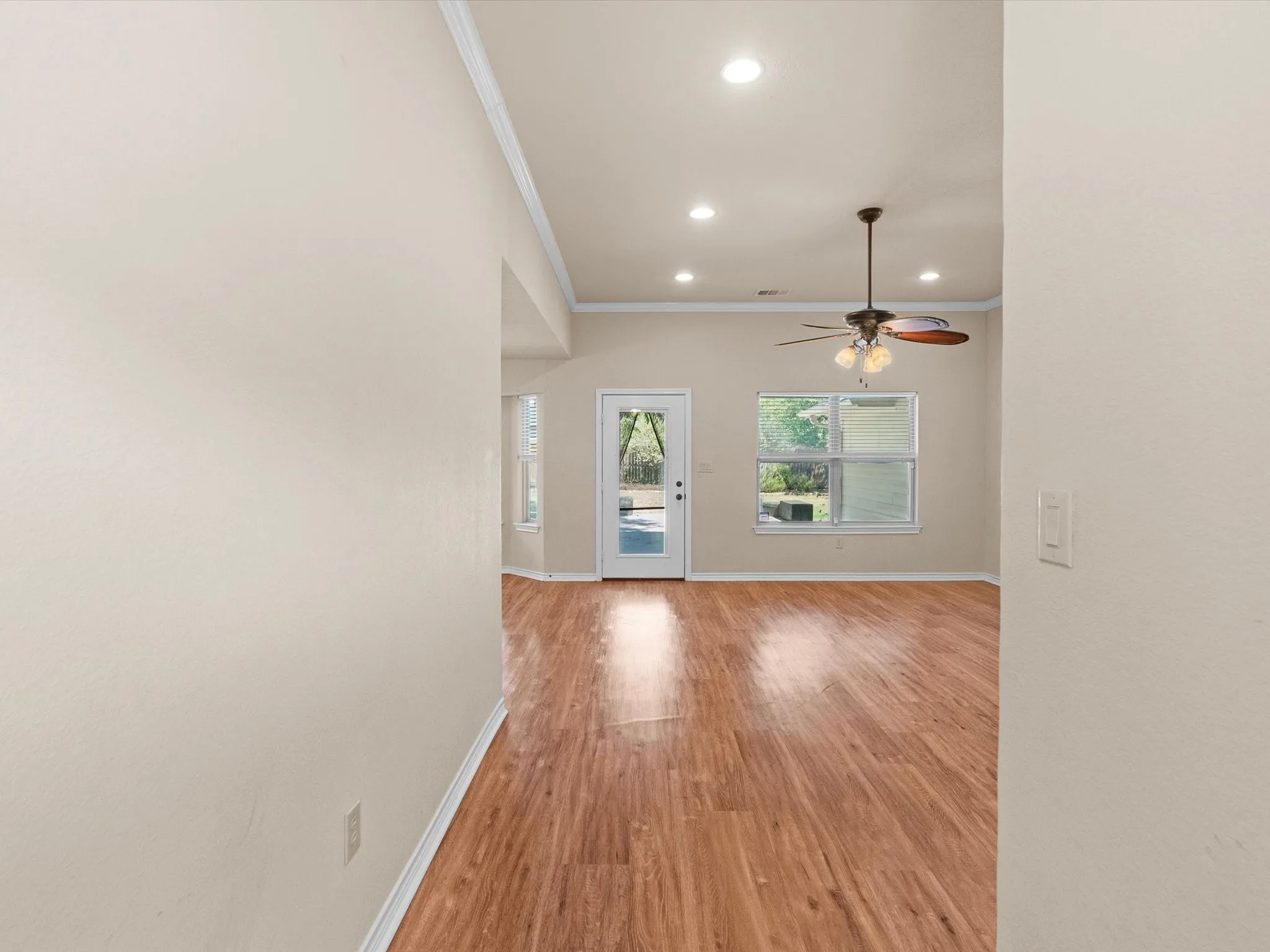 Recessed lighting, wood-finish flooring, ceiling fan, multiple windows, and a glass-paneled exterior door