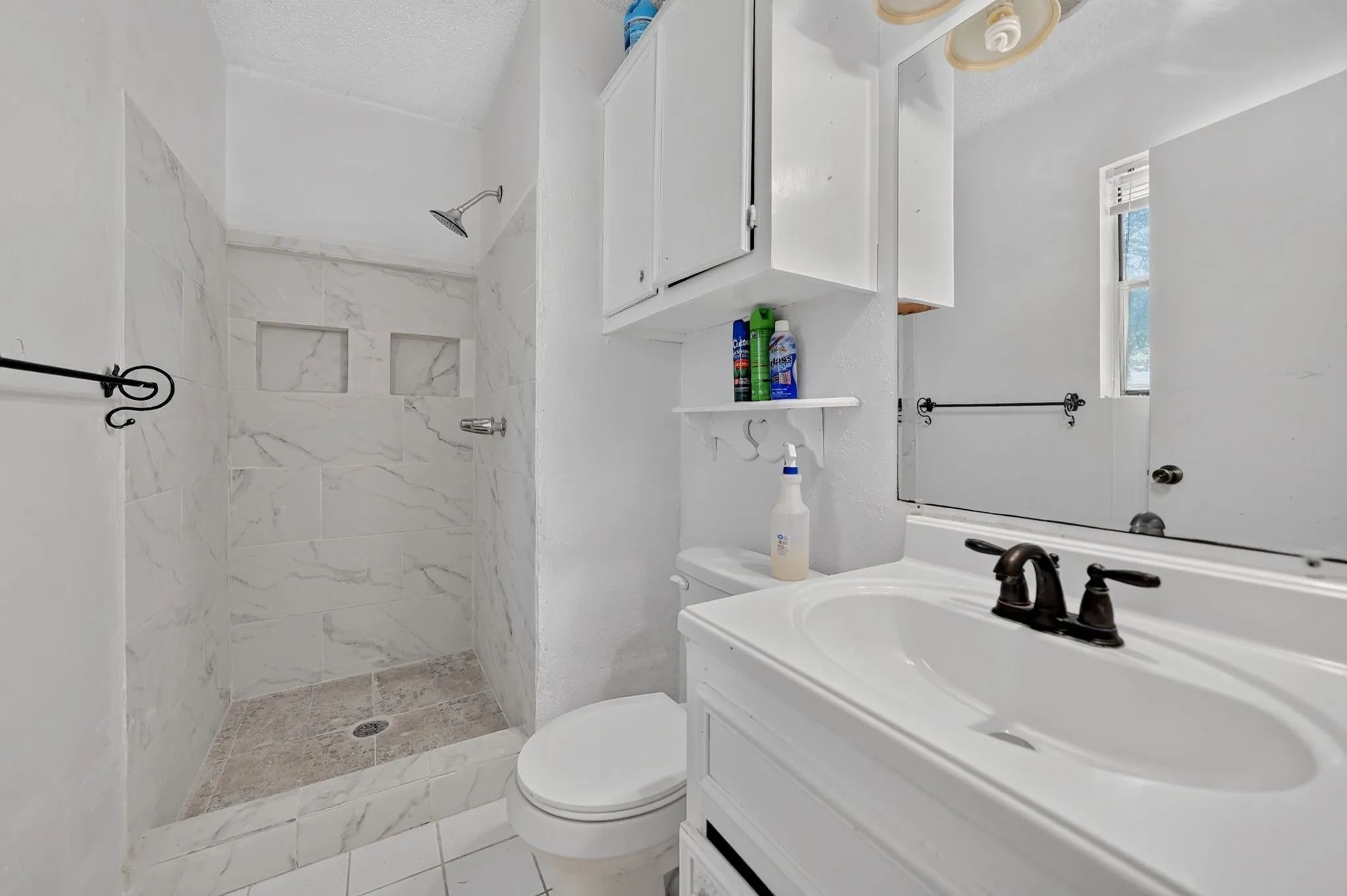 White vanity with an integrated sink and bronze-finish faucet