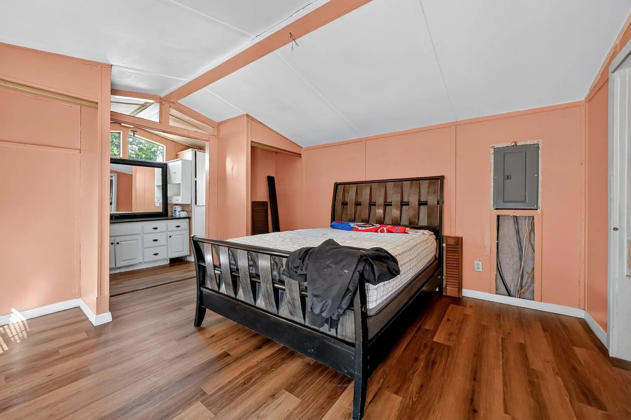 Wood-finish flooring with a sloped ceiling and exposed beams