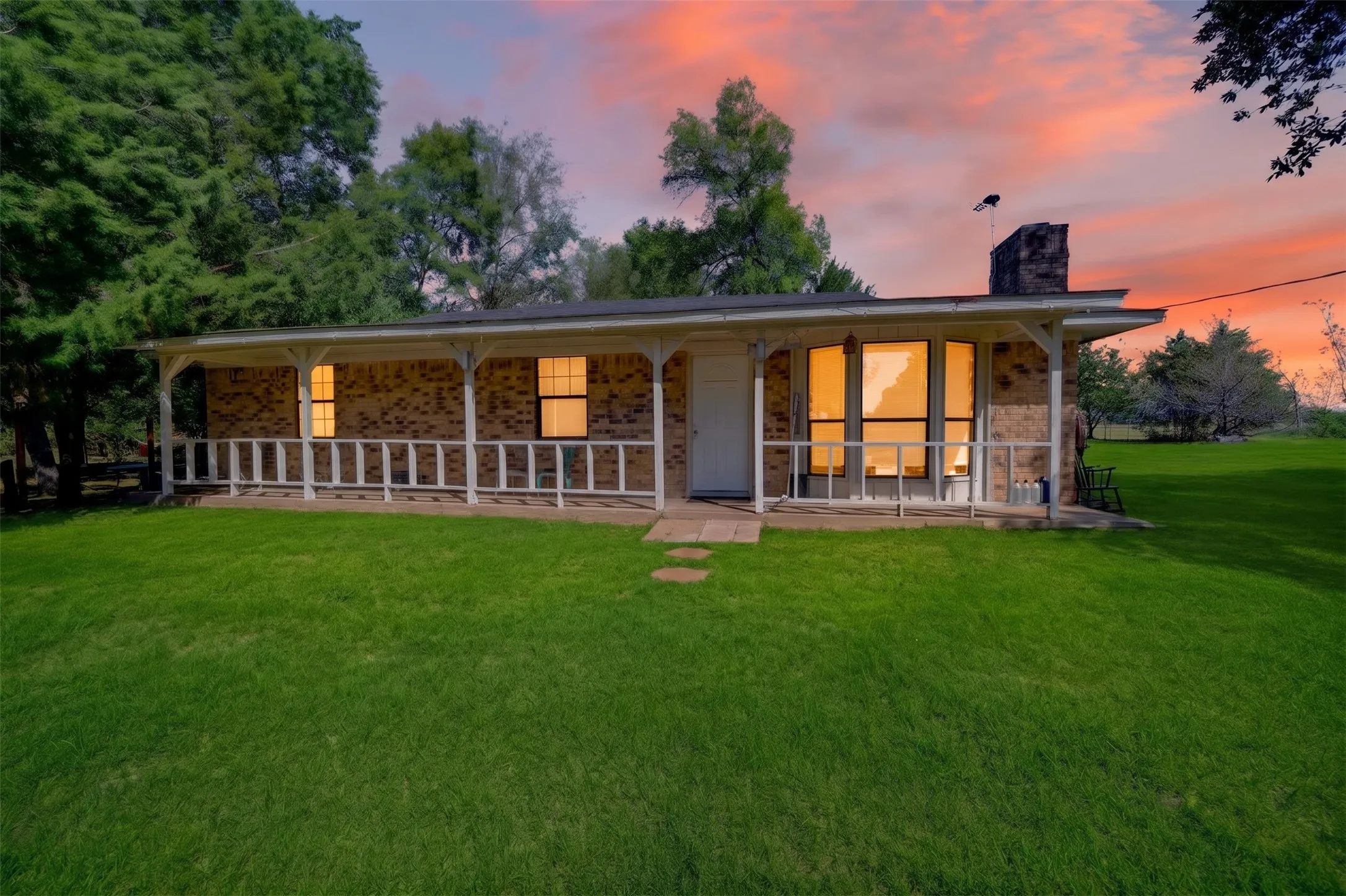 Brick exterior with a covered front porch featuring white railing and columns
