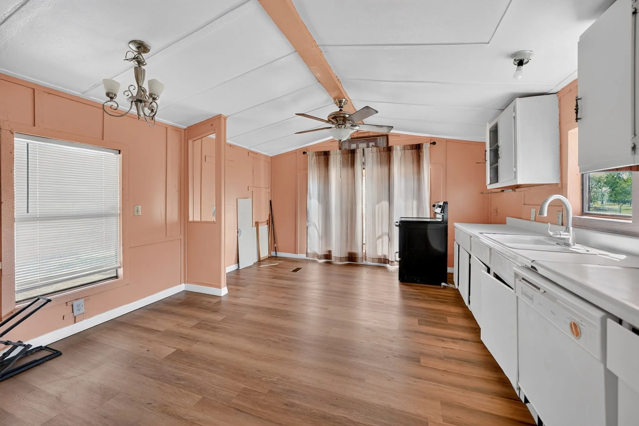 Wood-finish flooring throughout, white cabinetry, integrated dishwasher, and ceiling fan