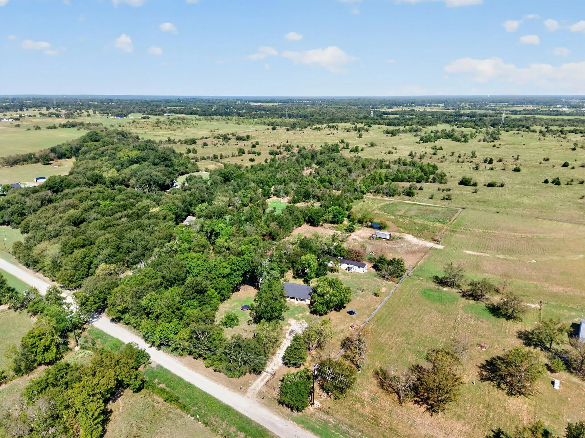 Expansive land parcel featuring a mix of open fields and densely wooded areas