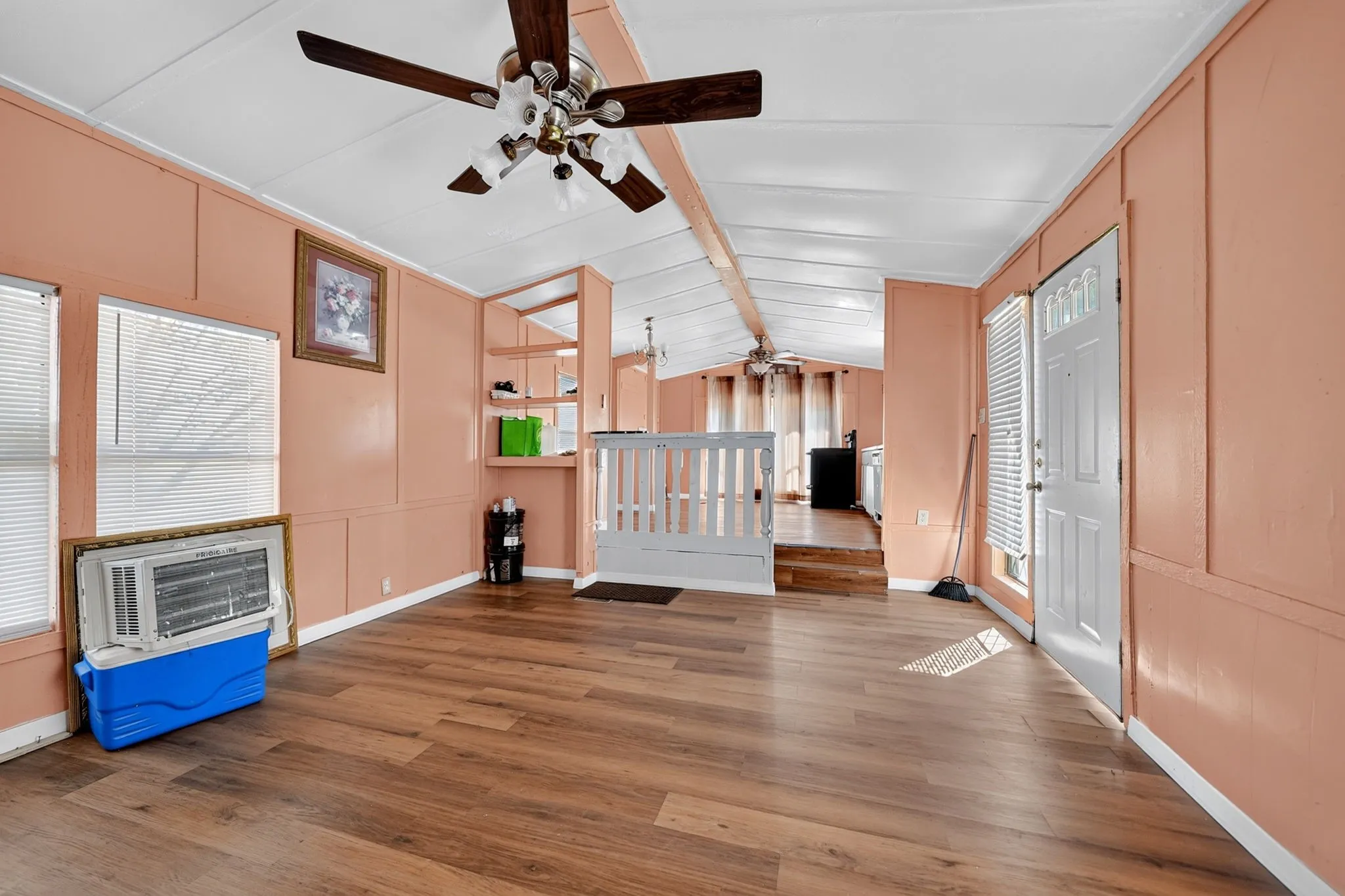 Wood-finish flooring, white paneled door with upper glass inserts, and built-in shelving