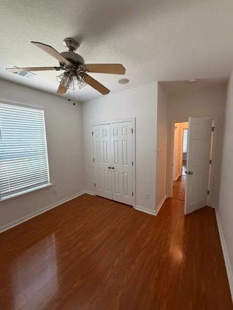 Wood-finish flooring, ceiling fan with light kit, double-door closet, recessed lighting, and window with horizontal blinds