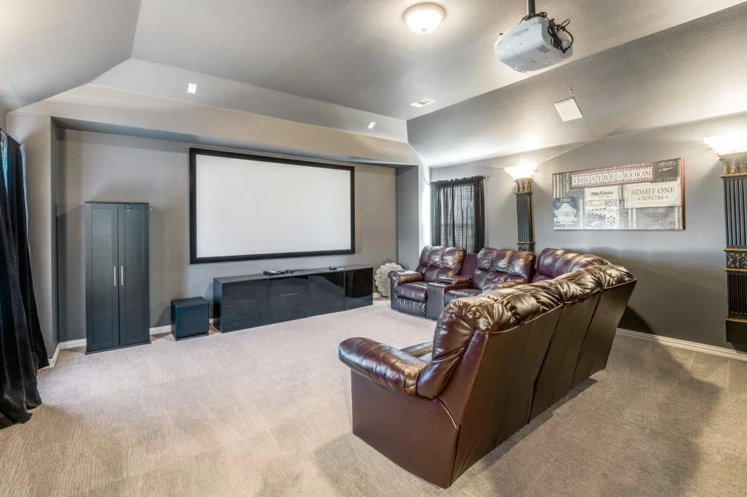 Integrated projector system, expansive screen, built-in media console, recessed lighting, and soft carpeting