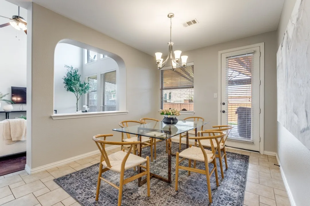 Arched wall opening, tile flooring, glass-paneled back door, and window with blinds