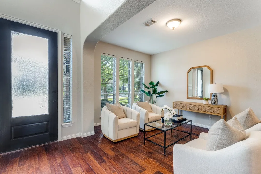Wood-finish flooring, multiple large windows with blinds, arched entryway, and recessed ceiling lighting